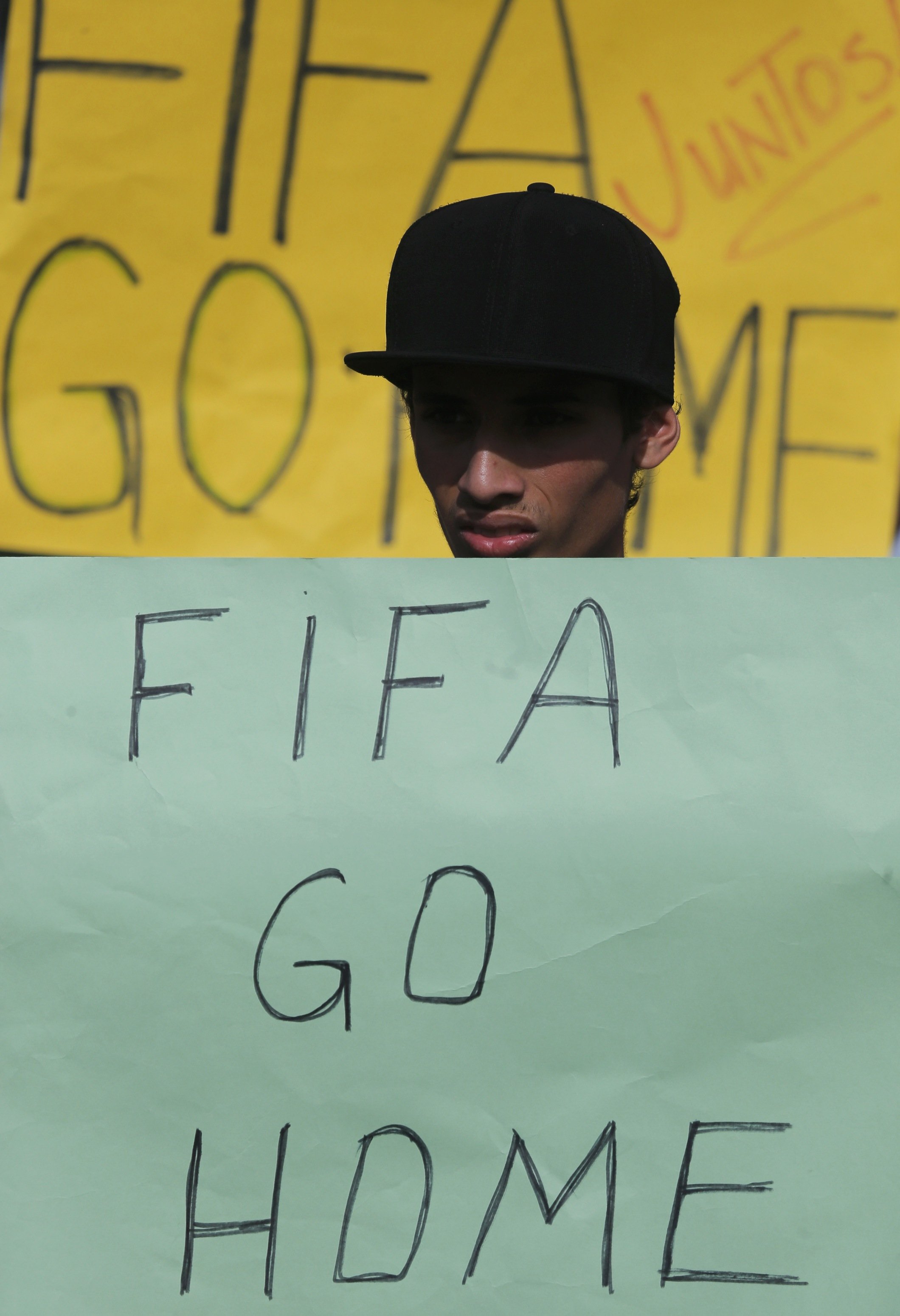 An activist holds a protest poster in front of the municipal stadium prior to a training session by Japan's national soccer in Sorocaba