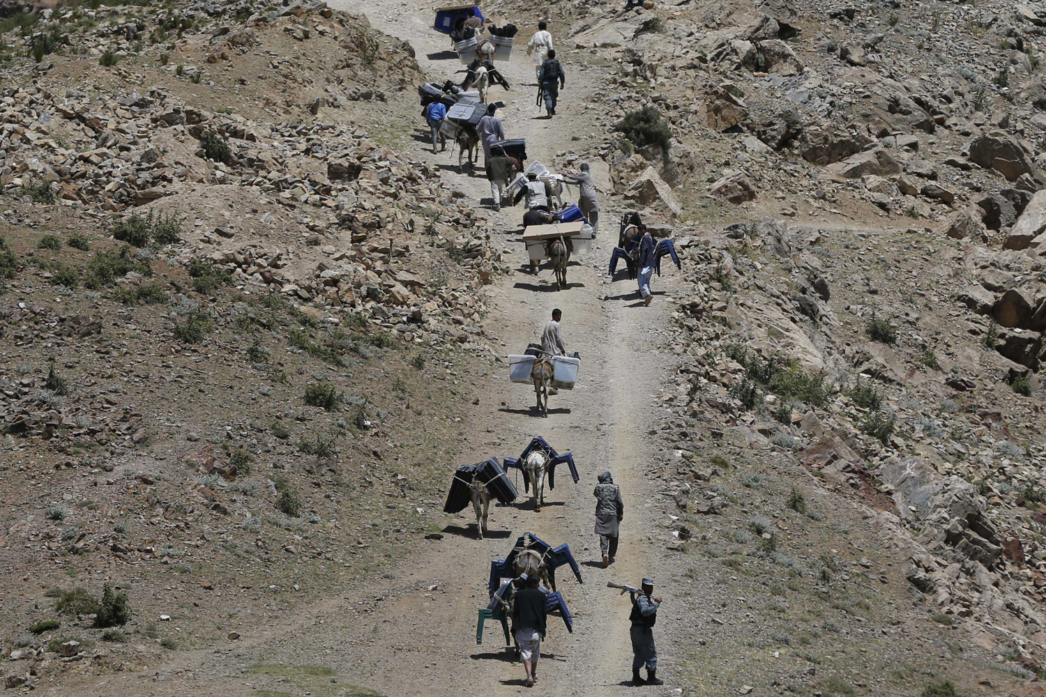 Afghan men lead donkeys loaded with ballot boxes and other election material to be transported to polling stations which are not accessible by road in Shutul, Panjshir