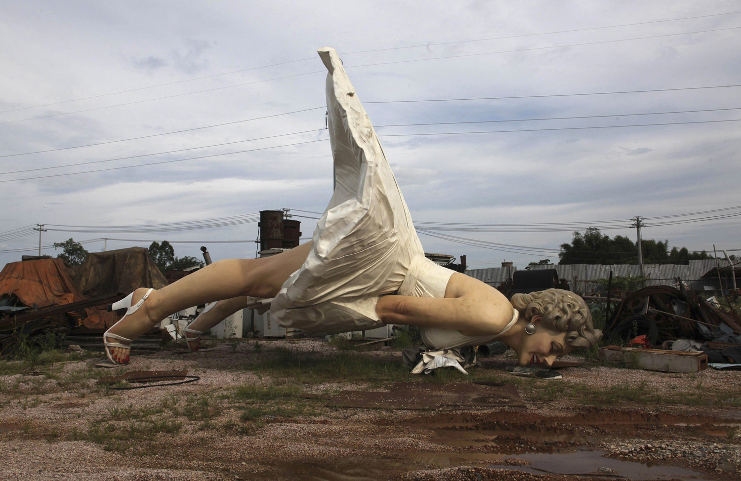 Giant statue of U.S. actress Marilyn Monroe is seen at the dump site of a garbage collecting company in Guigang