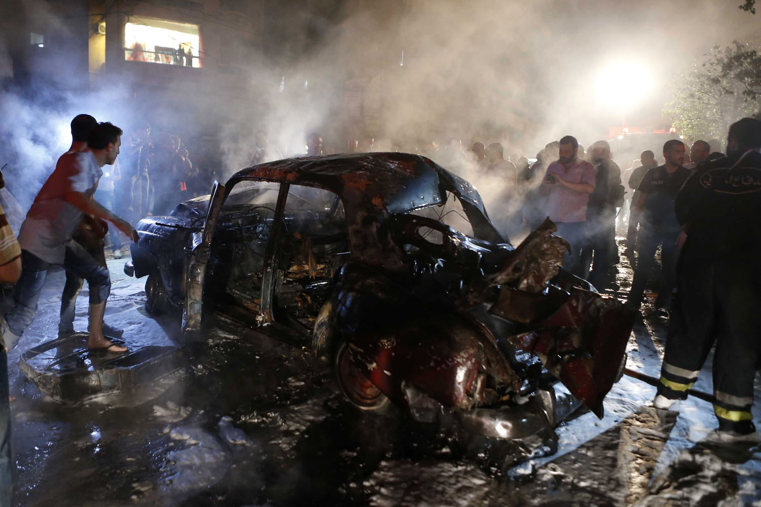 People gather at the site of an explosion at the southern suburbs of the Lebanese capital Beirut