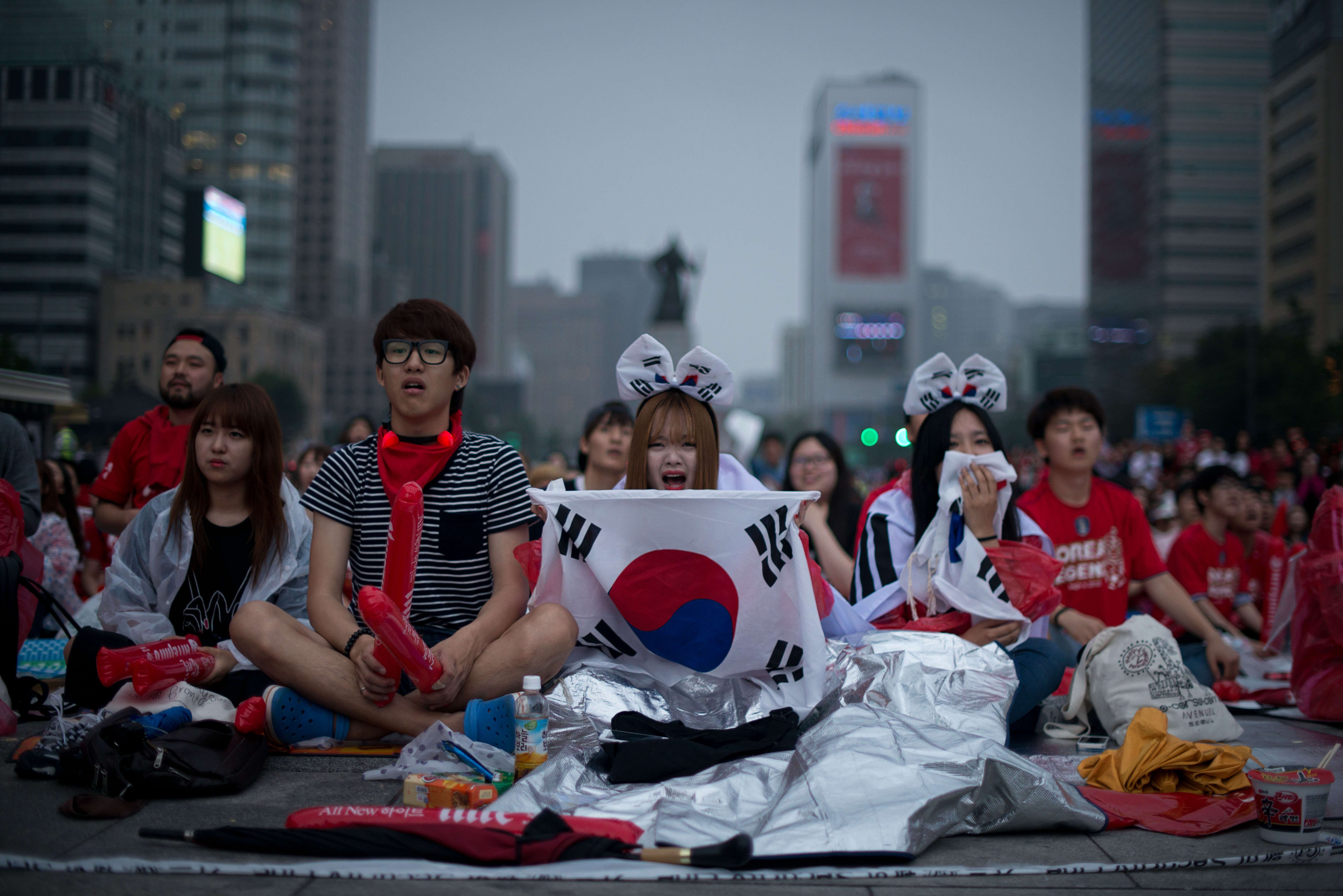 South Korean football fans react as their team loses to Algeria as they watch the match on giant screens in central Seoul on June 23, 2014.