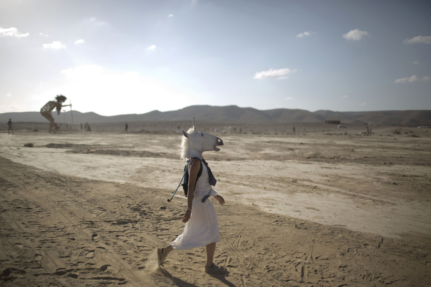 An Israeli woman wears a unicorn mask as she walks in the playa during Israelís first Midburn festival, modeled after the popular Burning Man festival, in the desert near the Israeli kibbutz of Sde Boker.