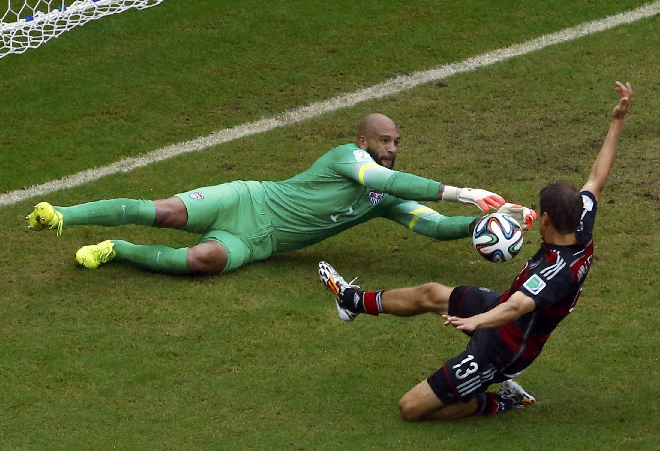 Germany's Thomas Mueller challenges goalkeeper Tim Howard of the U.S. during their 2014 World Cup Group G soccer match at the Pernambuco arena in Recife, Brazil on June 26, 2014.