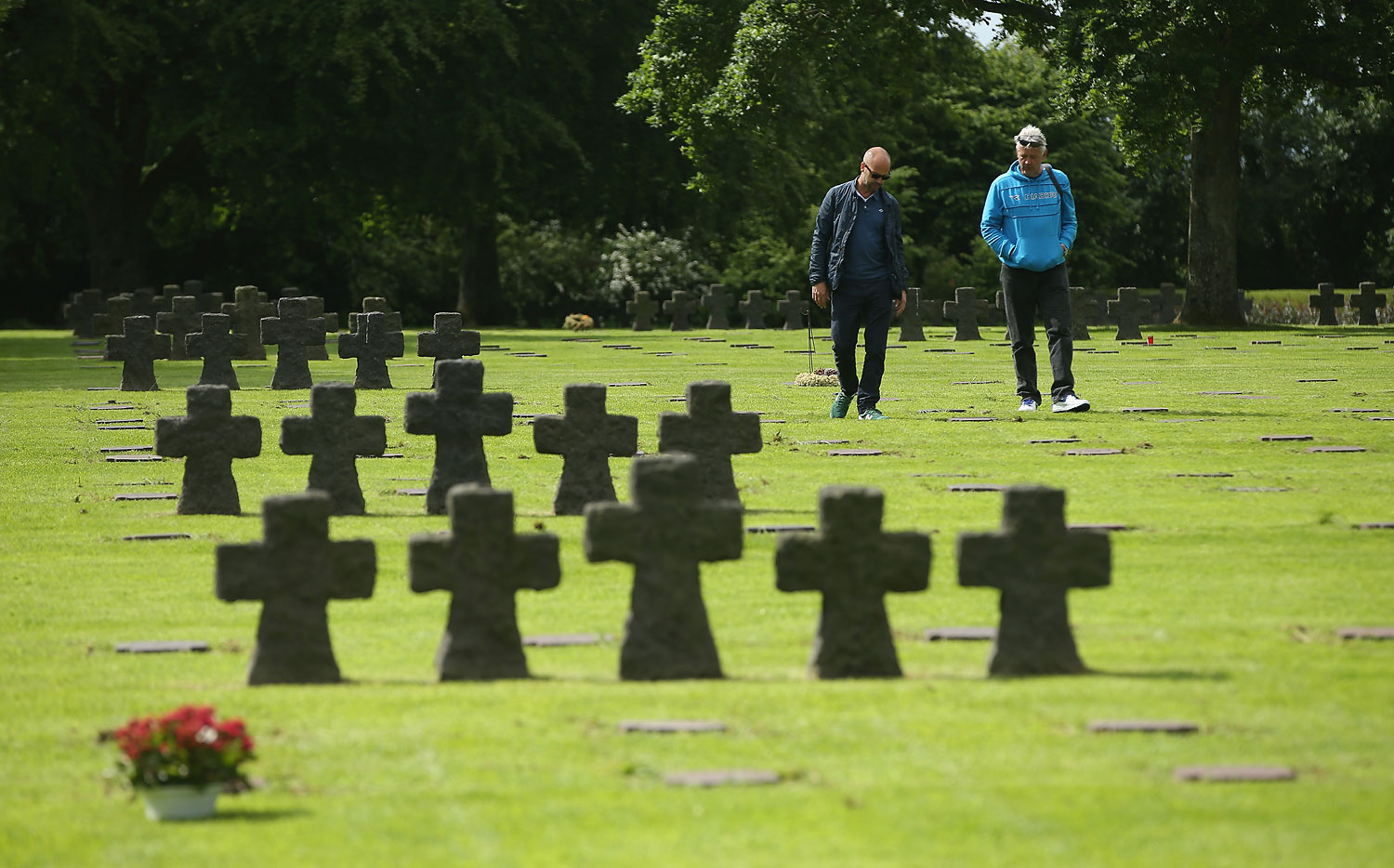 Visitors walk among gravestones at the German Cemetery where approximately 21,000 German World War II soldiers are buried on June 5, 2014 at La Cambe, France. (Sean Gallup—Getty Images)