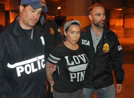 Samantha Barbash, center, is escorted by law enforcement officers following her arrest. Barbash is allegedly part of a crew of New York City strippers who scammed wealthy men by drugging them and running up extravagant bills at topless clubs while they were in a daze, according to authorities, New York City, June 9, 2014. (DEA/AP)