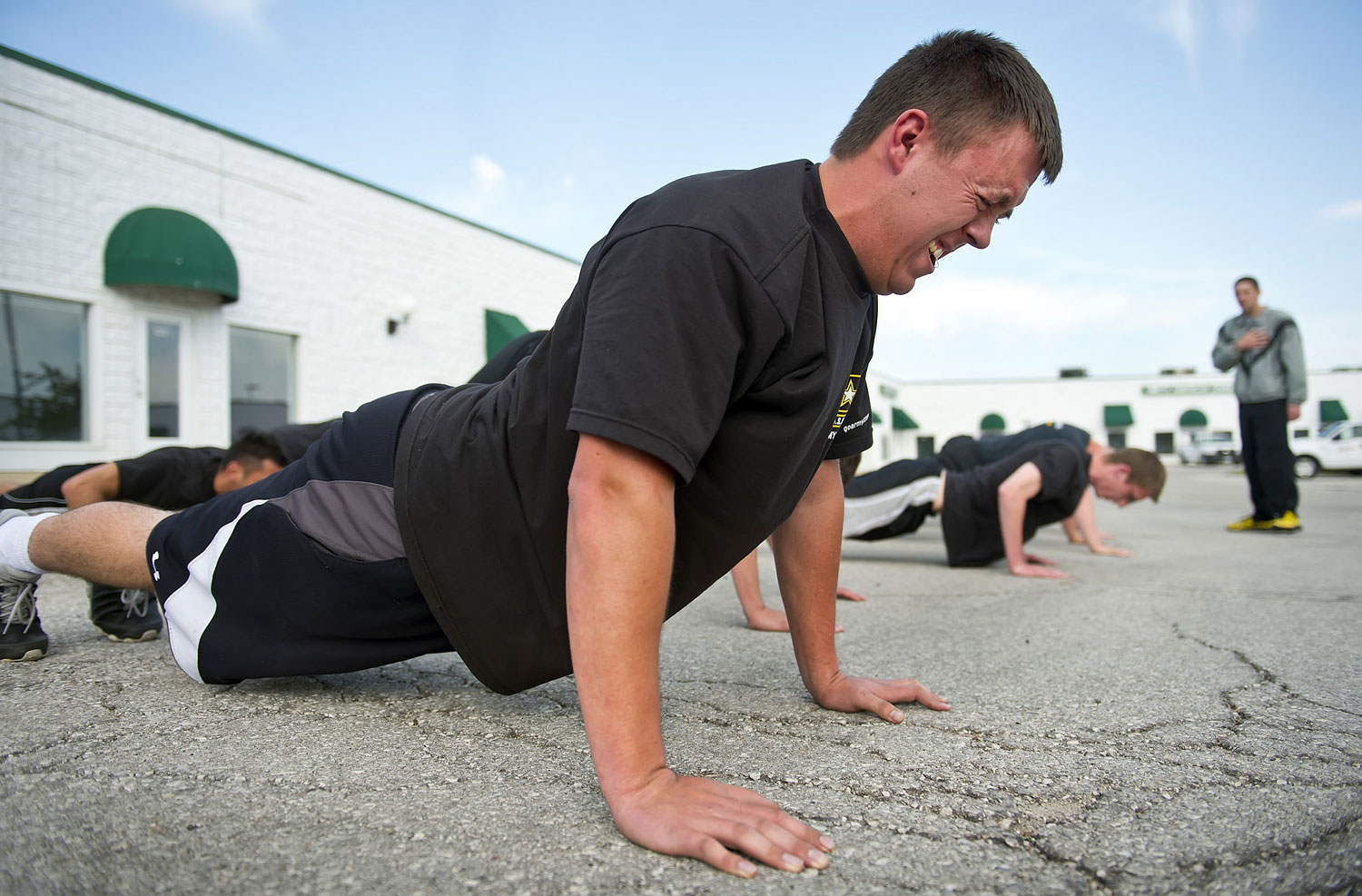 Kyle Bayard, 20, struggles to remain in position during a stationary push-up during physical exercise in the parking lot behind the Army recruiting station in Grandview, Mo., May 6, 2014. (David Eulitt—MCT/Getty Images)