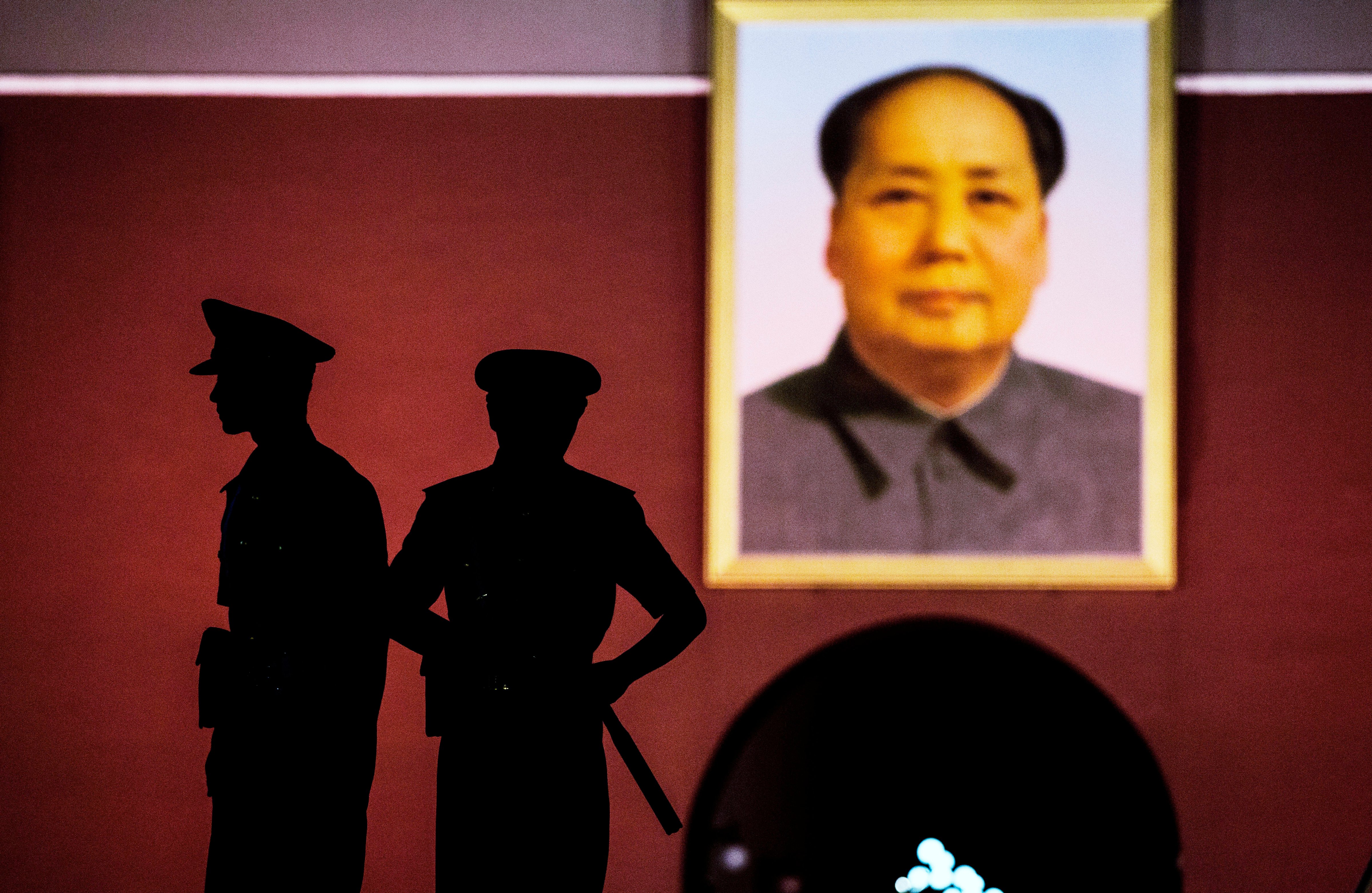 Chinese Paramilitary security force officers stand under a portrait of the late Mao Zedong outside the Forbidden City at Tiananmen Square on June 2, 2014 in Beijing, China. (Kevin Frayer—Getty Images)