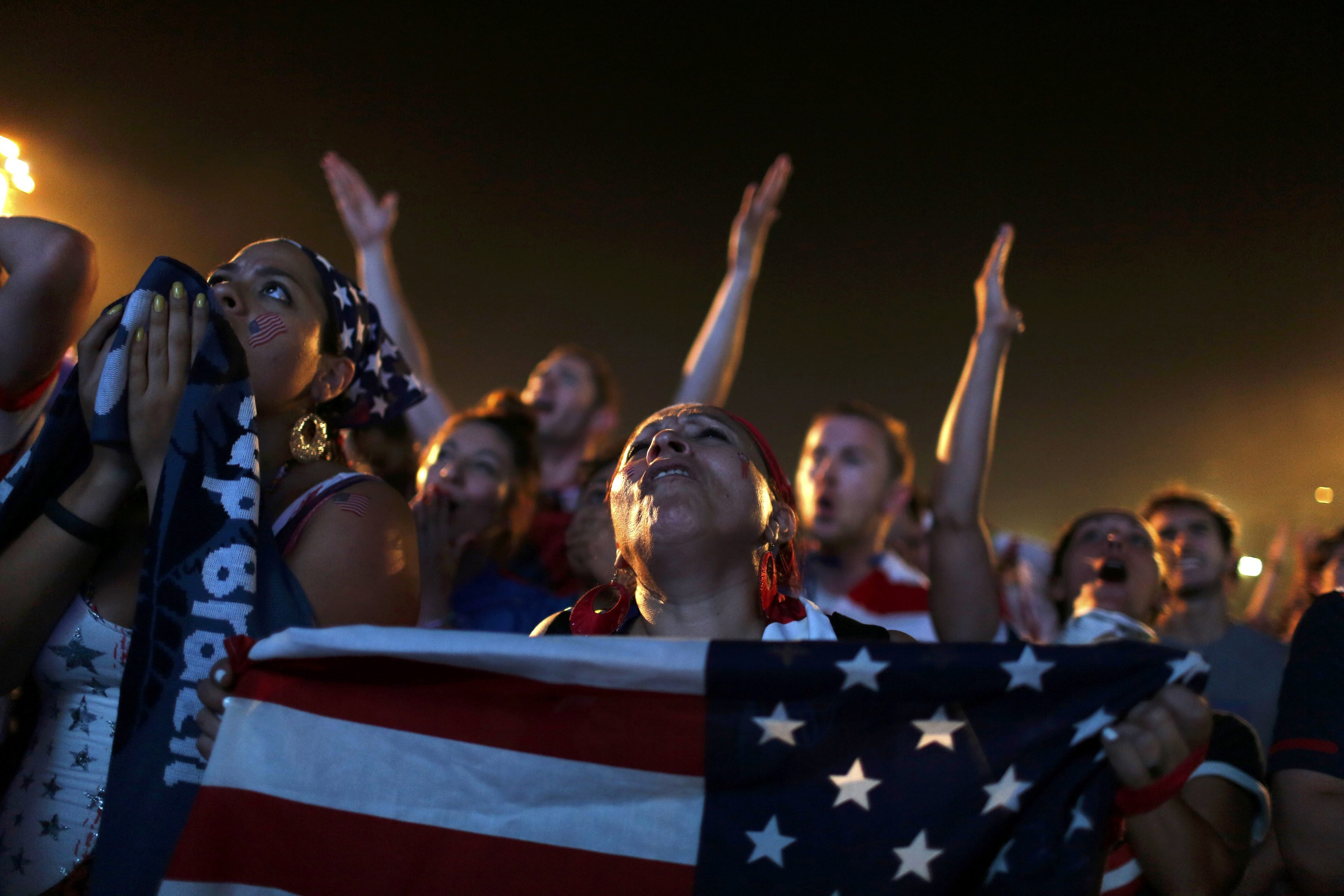 U.S. fans react as they watch the match between U.S. and Ghana on a large screen at Copacabana beach in Rio de Janeiro on June 16, 2014.