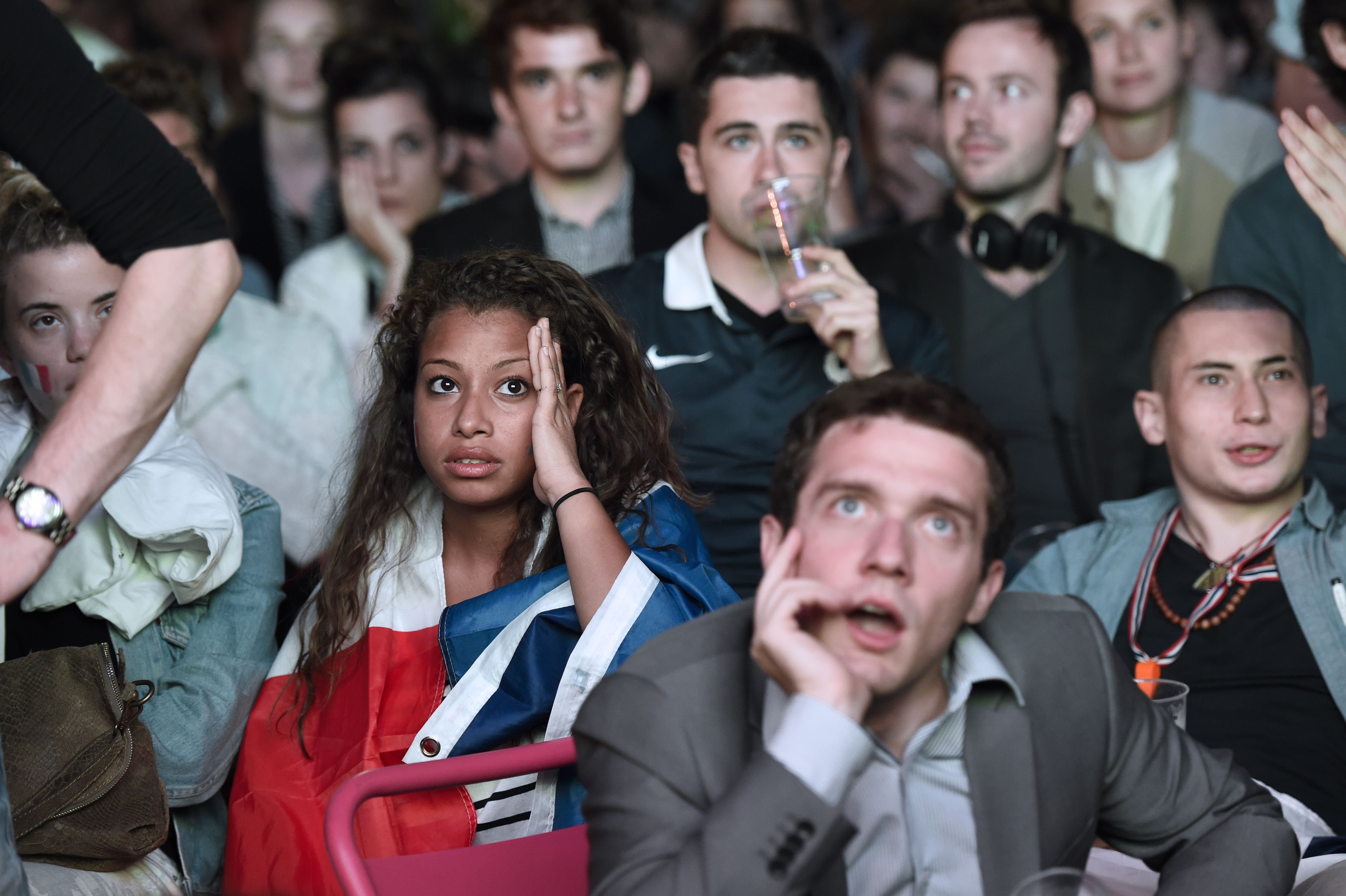 Spectators react as they watch the match between France and Ecuador on a screen in central Paris on June 25, 2014.