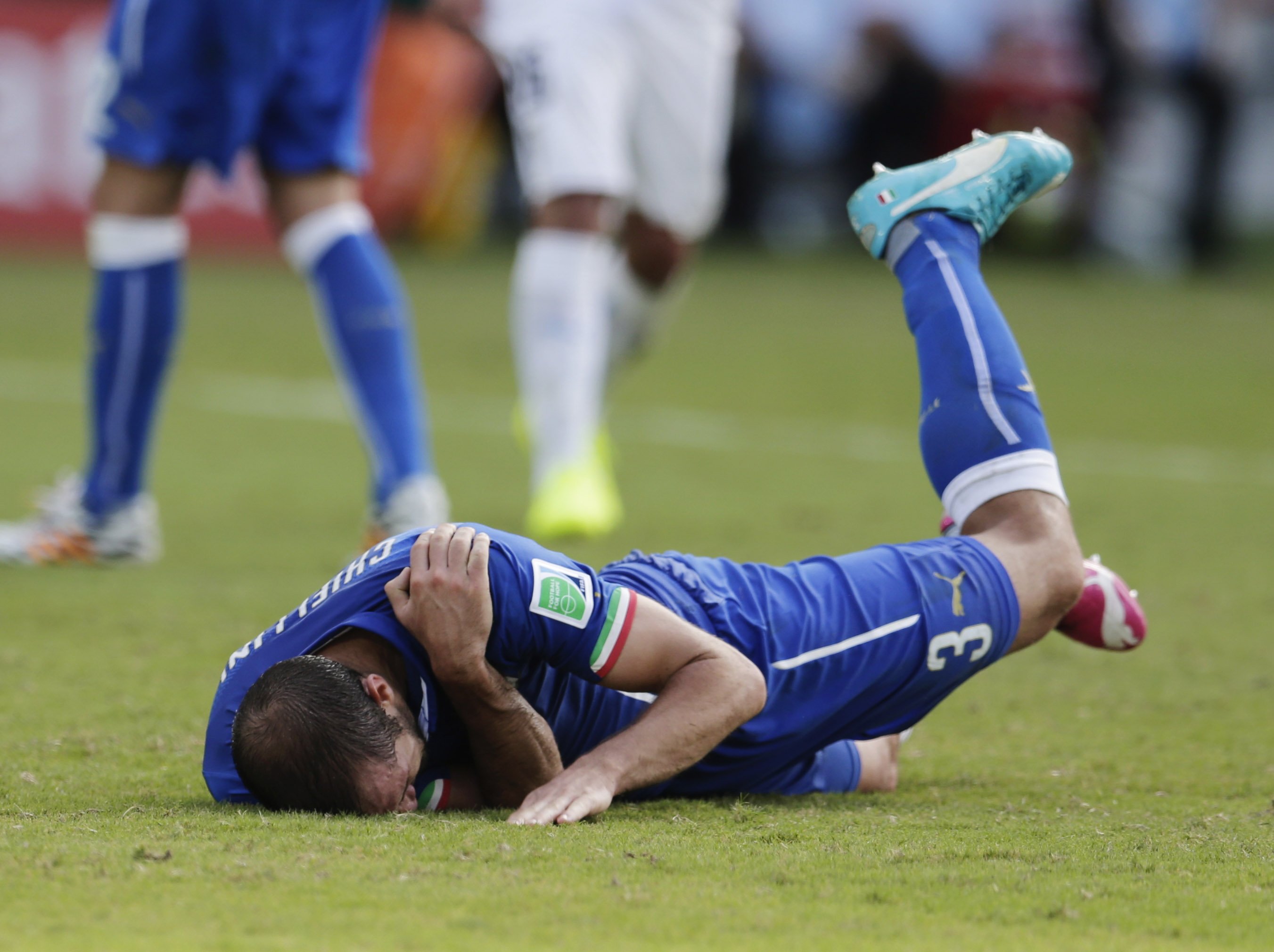Italy's Giorgio Chiellini holds his shoulder after Uruguay's Luis Suarez ran into it with his teeth during the group D World Cup soccer match between Italy and Uruguay at the Arena das Dunas in Natal, Brazil on June 24, 2014.