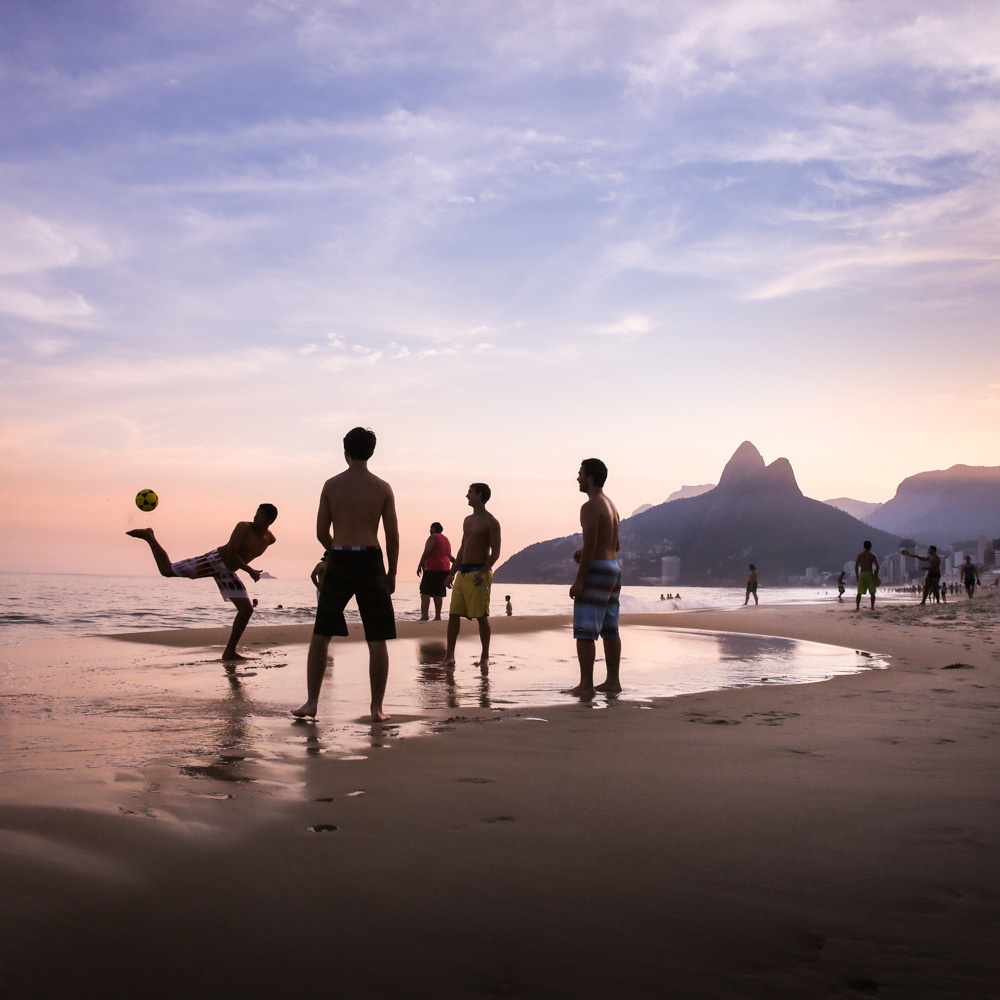 May 16, 2014. Local men are play football on the beach in Ipanema at sunset, Rio De Janeiro, Brazil