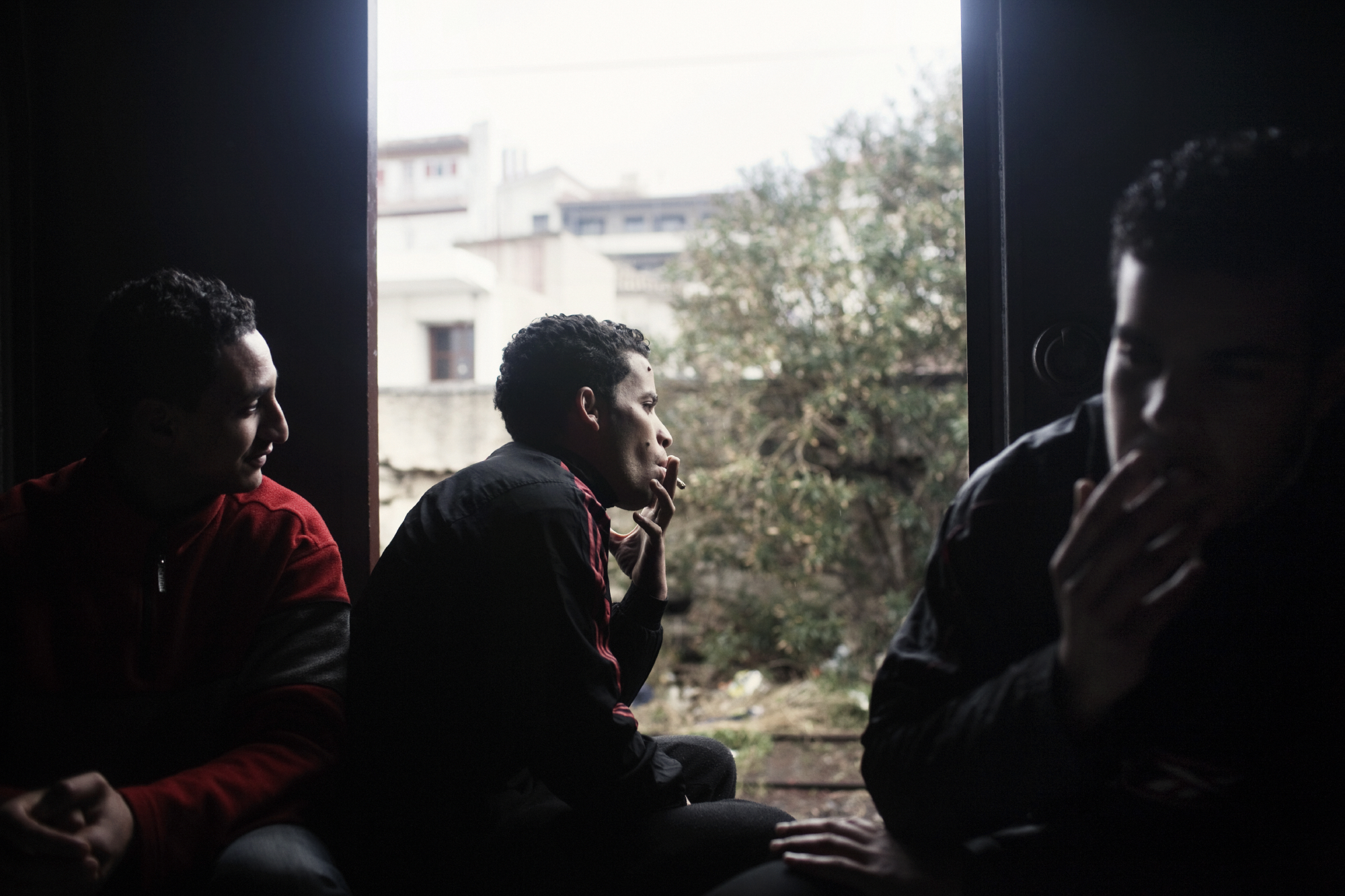 2012. Corinth. Greece. Mohammed, Ahmed and Nabi from Morocco in the wagon wherethey live in the abandoned train station of Corinth. In Corinth, a small sea town on the Peloponnese, the boarding of boats directly is attempted by group of North Africans who have established themselves in an old train station.