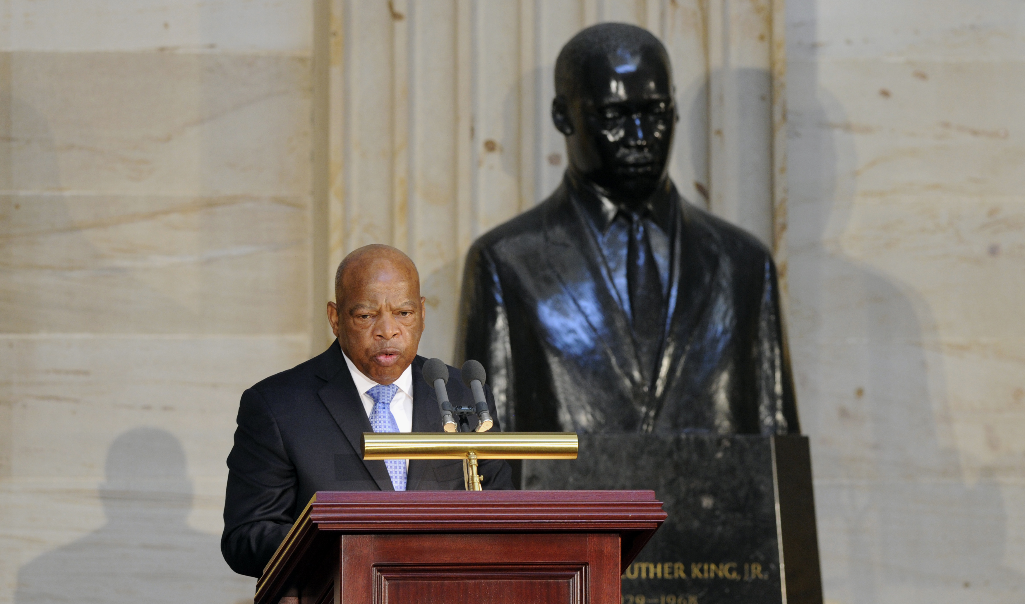 Democratic Representative John Lewis of Georgia stands in front of a statue of Martin Luther King Jr. as he speaks during the 50th anniversary ceremony for the Civil Rights Act of 1964 on Capitol Hill, in Washington, D.C., on June 24, 2014 (Susan Walsh—AP)