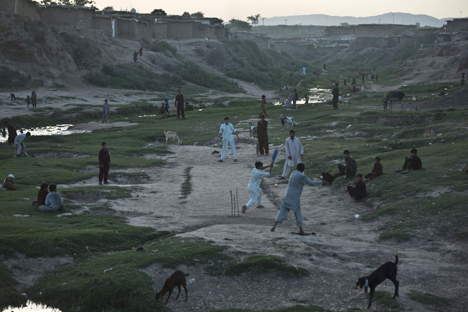 Internally Displaced Pakistanis from tribal areas and Afghan refugees play cricket, on the outskirts of Islamabad, Pakistan on June 3, 2014.