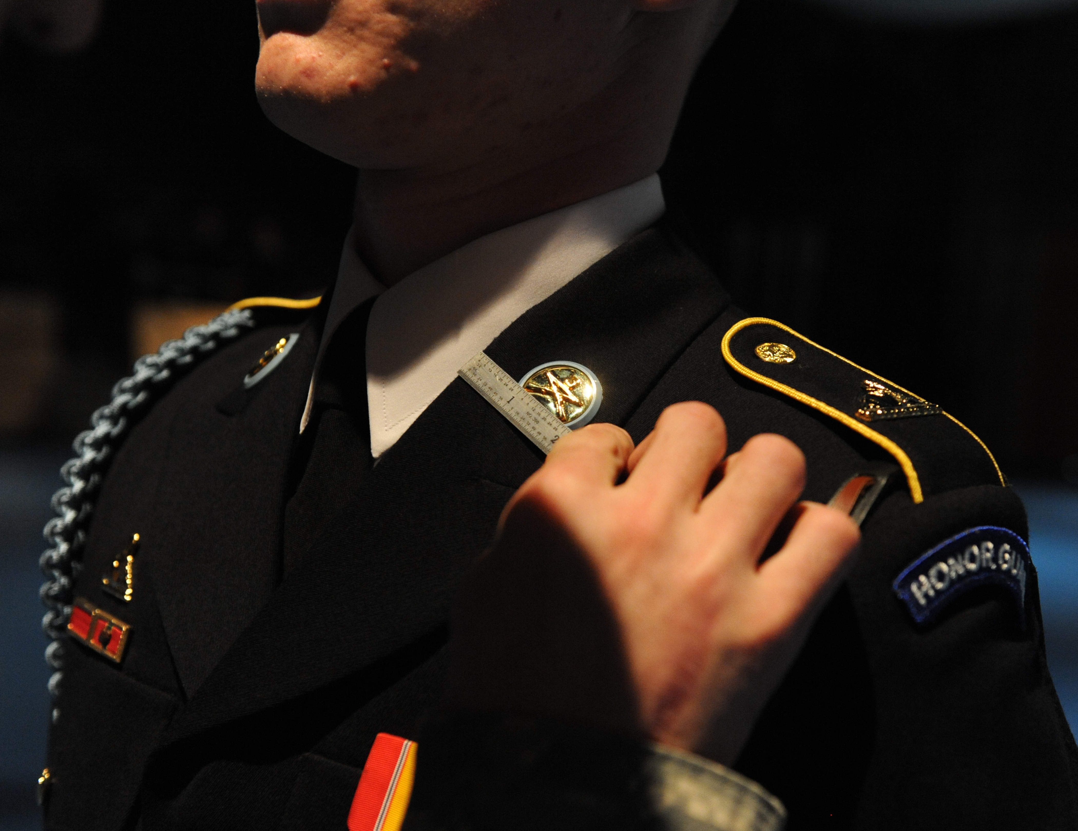 Pfc. Stephen Polidore has the details of his uniform closely scrutinized by Sgt. Jesse Levenson as members of the Old Guard who participate in funerals at Arlington Cemetery go through a semiannual refresher training in Arlington, Va., April 8, 2010.