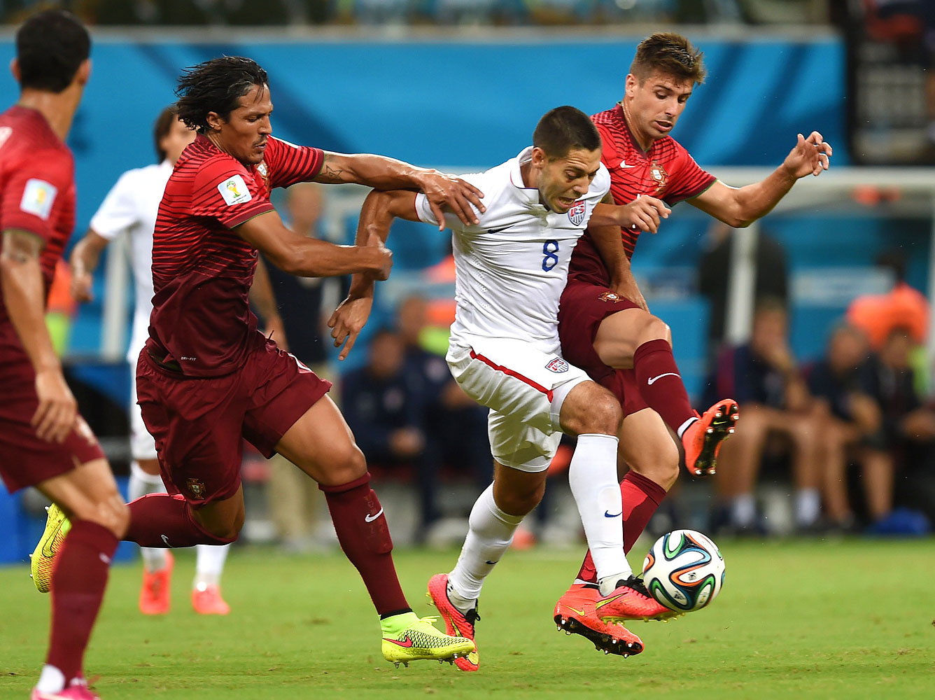 United States' Clint Dempsey, centre, is challenged by Portugal's Bruno Alves, left, and Portugal's Miguel Veloso, right.