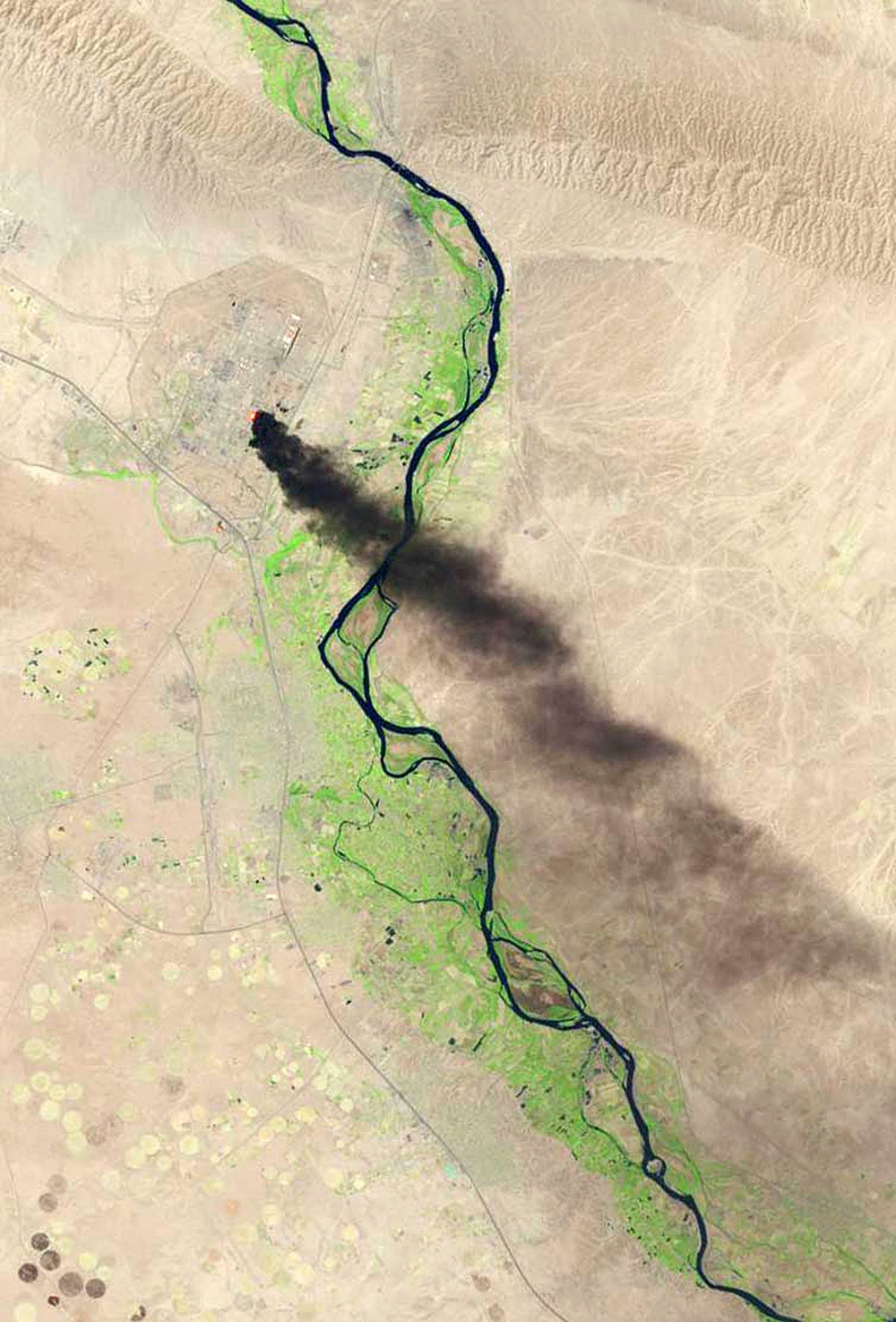 A satellite view shows smoke billowing from the key oil refinery complex in Baiji on June 18, 2014.