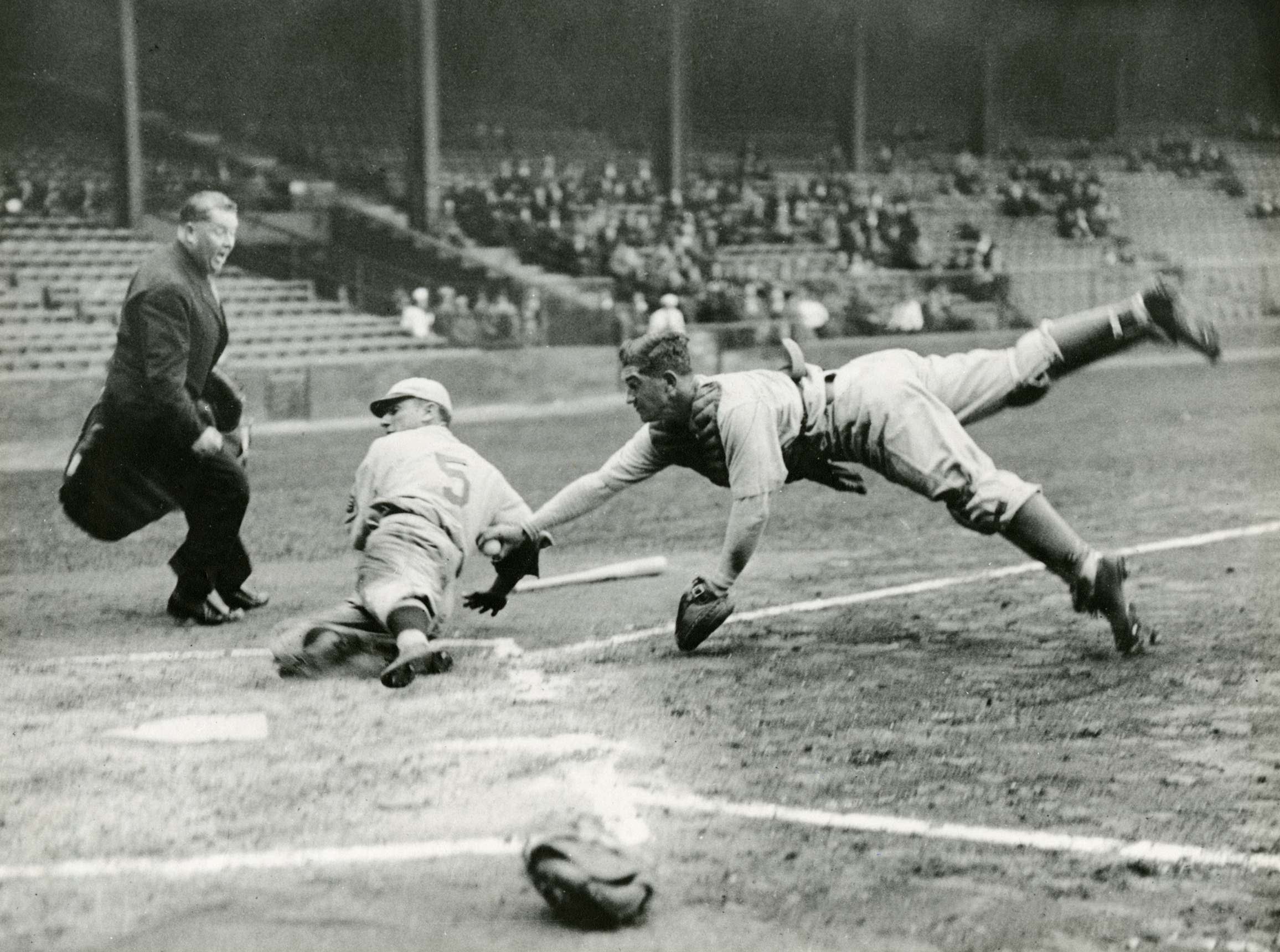 As part of the annual preseason City Series between Philadelphia's two major league clubs, Athletics catcher Mickey Cochrane dives home and tags out Phillies base runner Pinky Whitney at Shibe Park in Philadelphia, April 1, 1933.