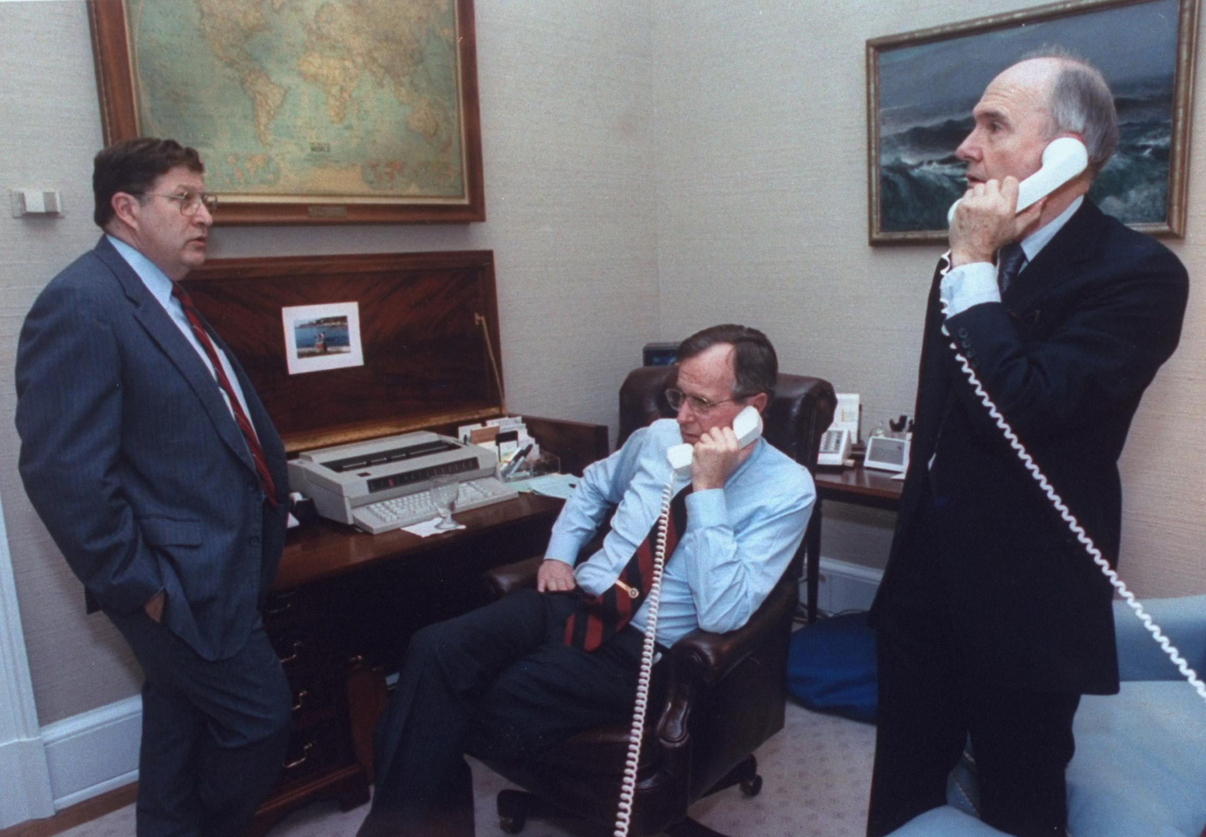 President George H.W. Bush on the phone with State Secretary Jim Baker during the gulf crisis, with White House Chief of Staff John Sununu &amp; National Security Council Adviser Brent Scowcroft, at the White House in Washington on January 16, 1991.