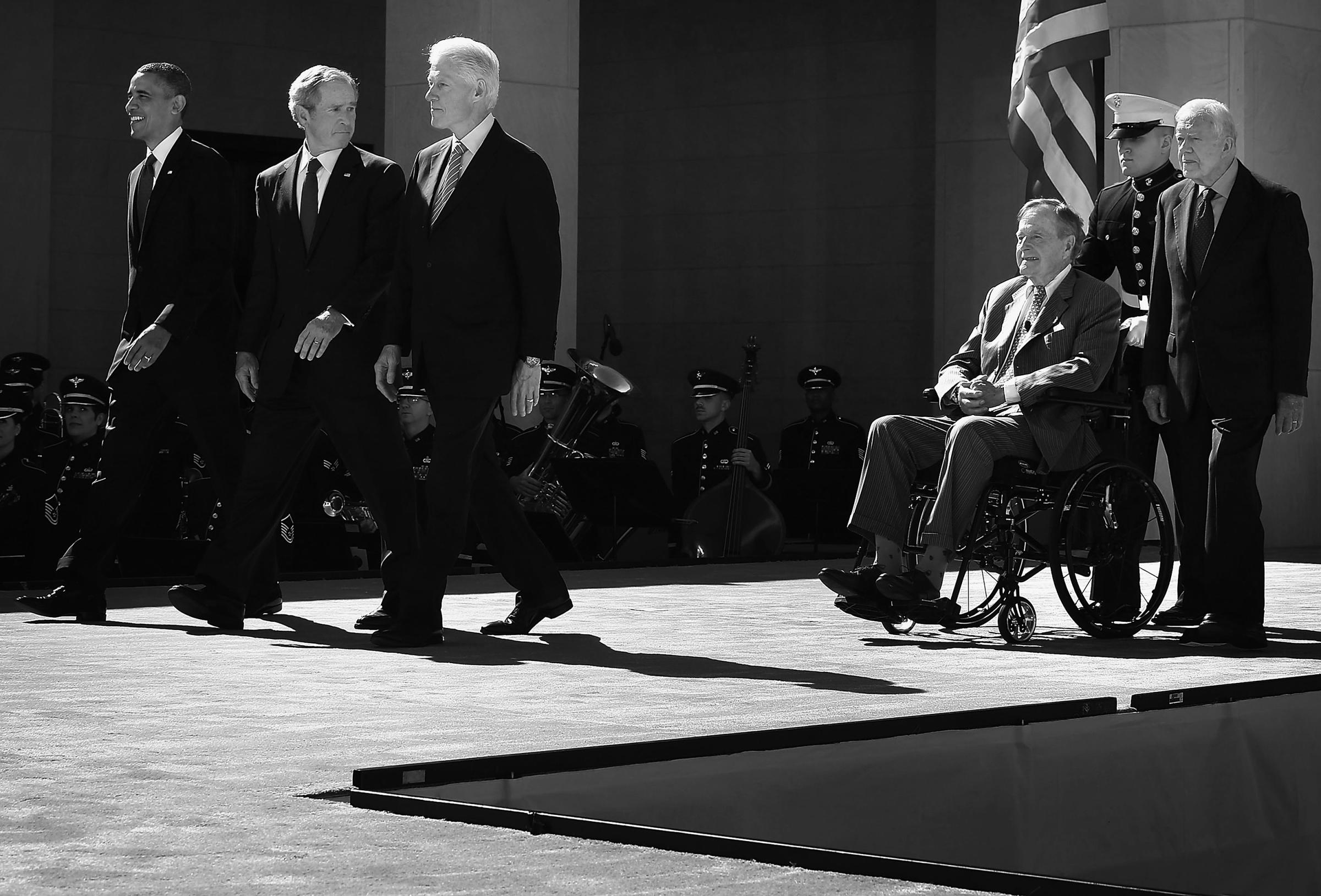 Former U.S. President George W. Bush turns around and checks on his father and former President George H.W. Bush as all five living presidents, including Barack Obama, Bill Clinton and Jimmy Carter, come out on stage during the opening ceremony of the George W. Bush Presidential Center on April 25, 2013 in Dallas, Texas.