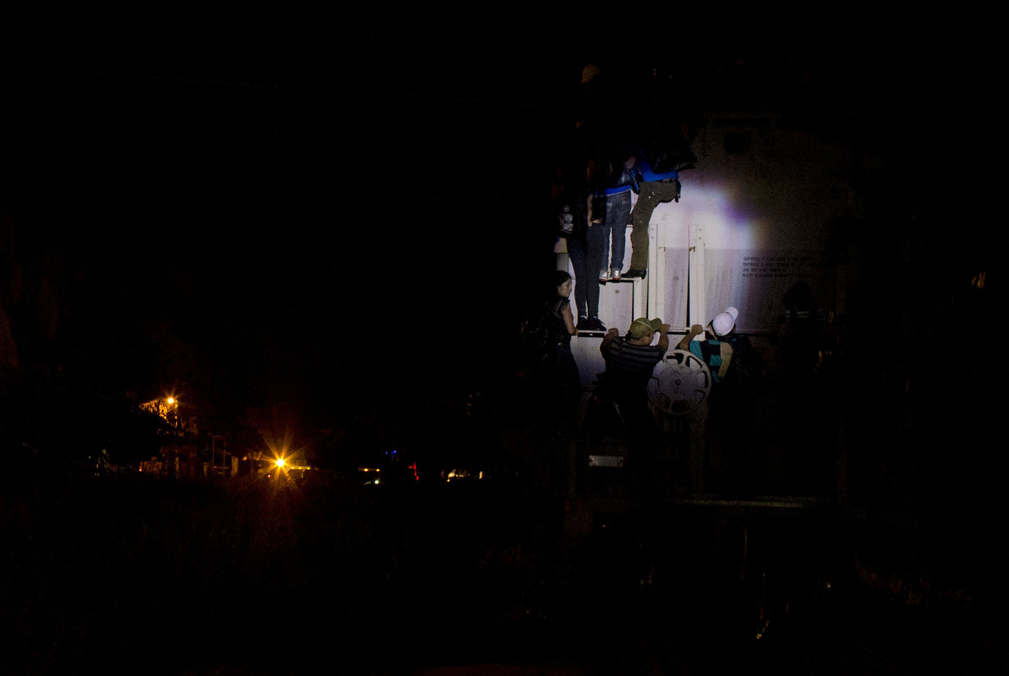 Central American migrants scramble to climb onto a moving freight train, as it pulls into the station in Arriaga,  Mexico, June 19.