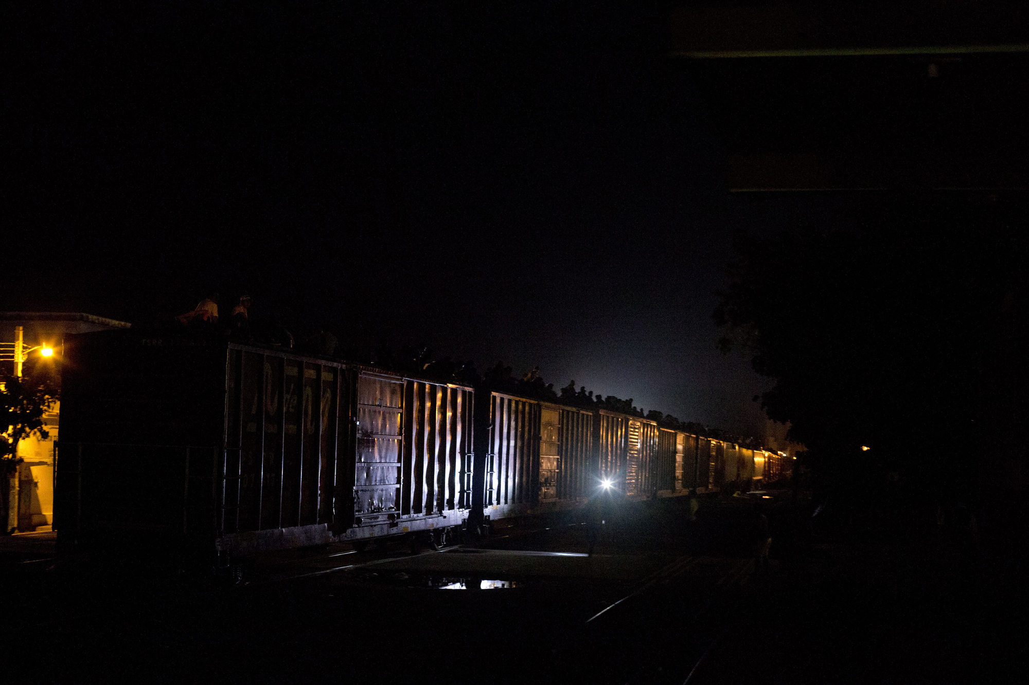 Migrants huddle on the roof of a northbound freight train as it pulls out of the station in Arriaga, Mexico, June 19.