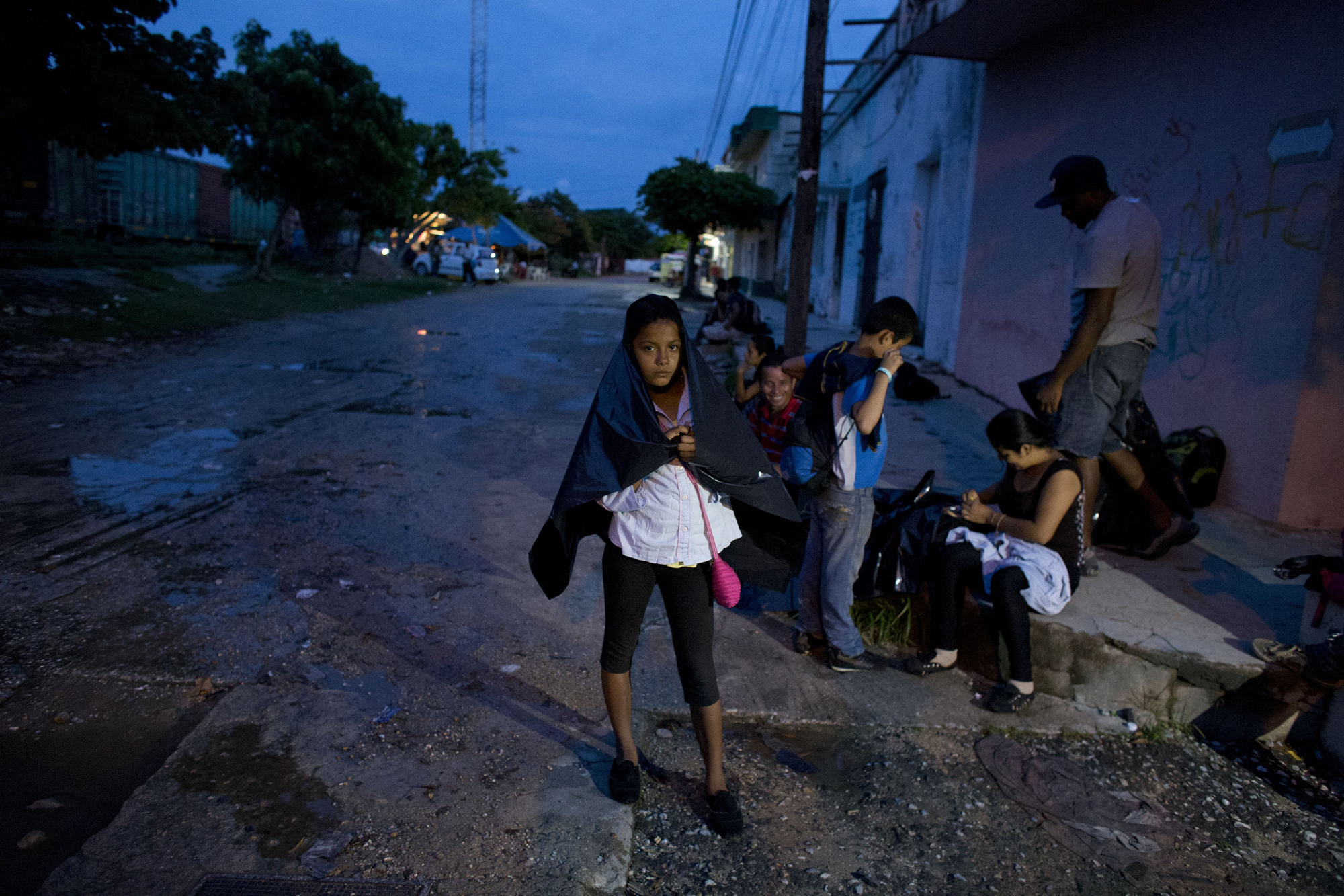 Cynthia Lemus, 12, waits with her family and other Central American migrants, for the arrival of a northbound freight train, in Arriaga, Mexico, June 19.