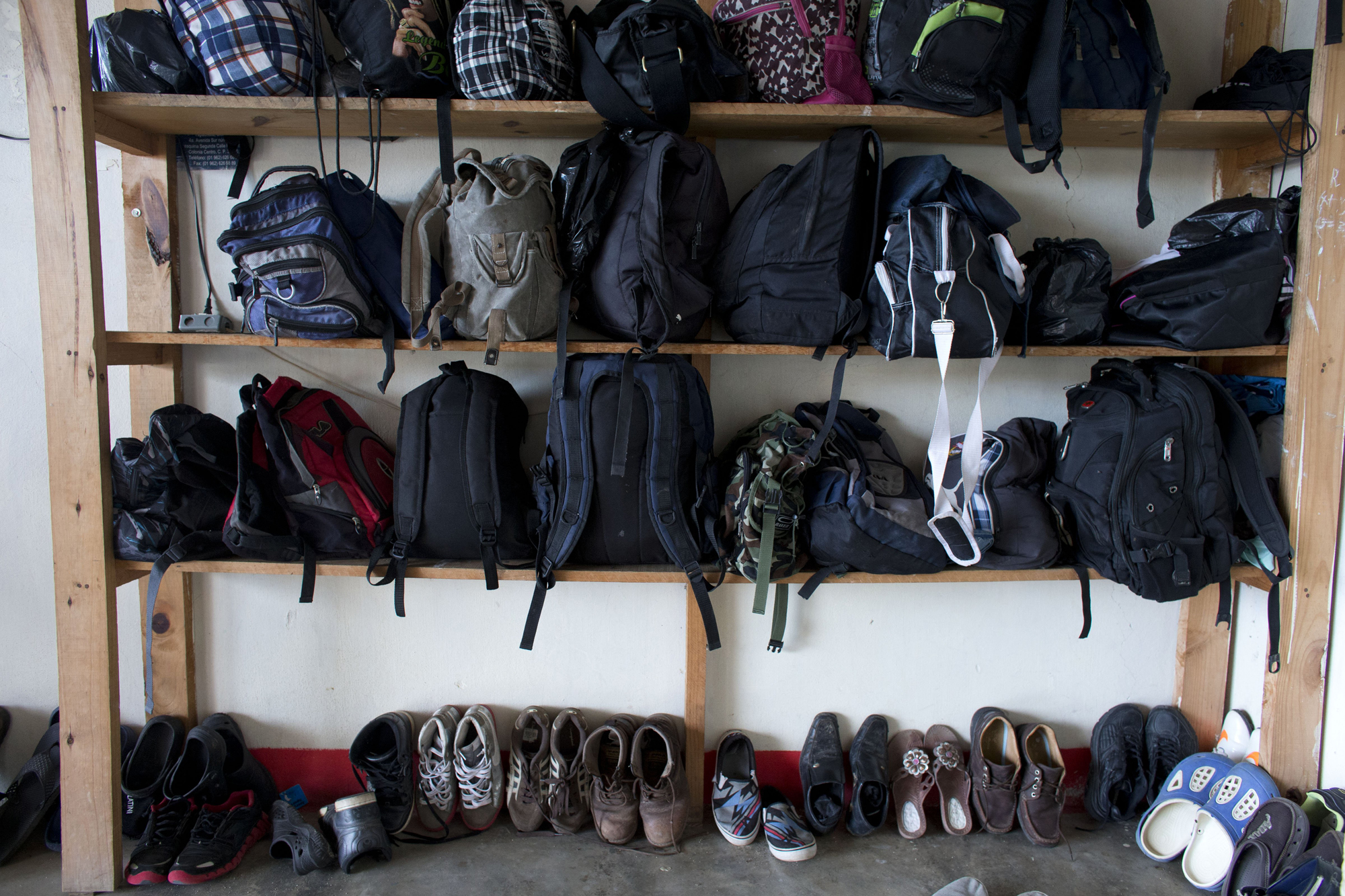 Migrants' bags and shoes line the edge of the room in the men's section of a shelter providing temporary refuge to Central Americans traveling north toward the U.S., in Arriaga, Chiapas State, Mexico, June 18.