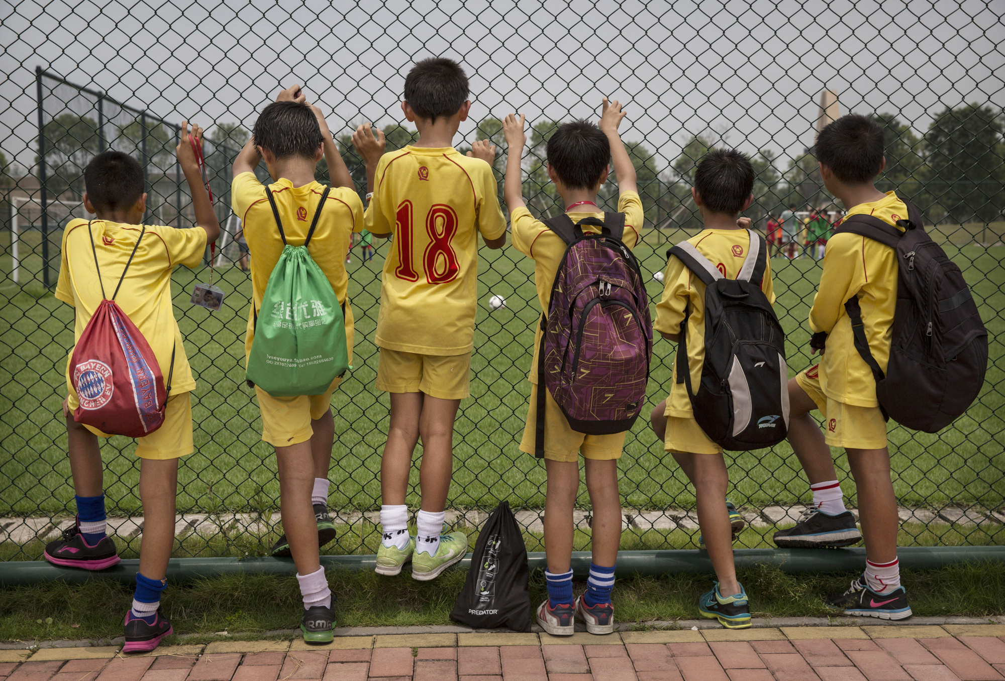 Players watch others train at the Evergrande International Football School.