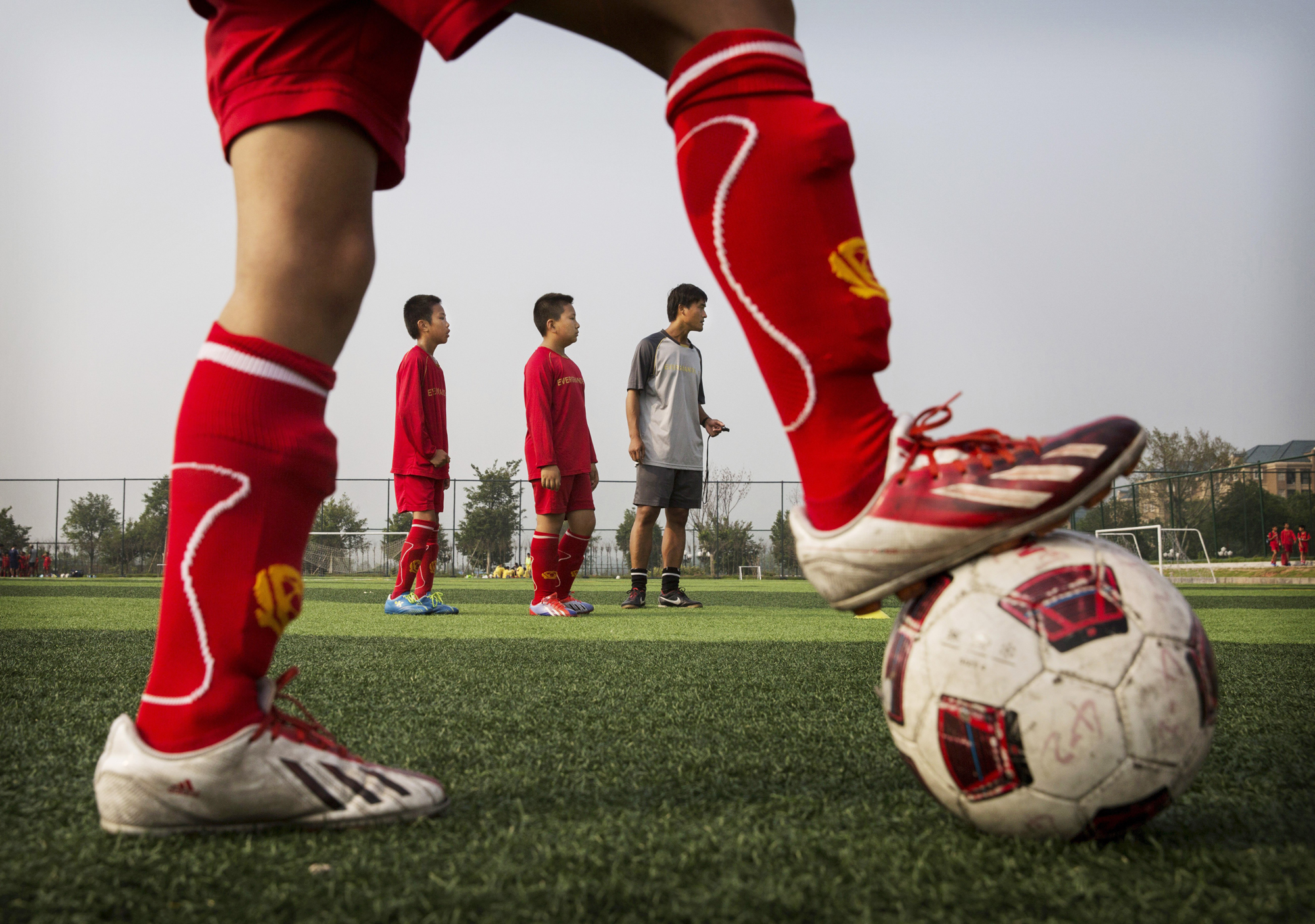 A coach interacts with students during training at the Evergrande International Football School on June 14 near Qingyuan in Guangdong Province.