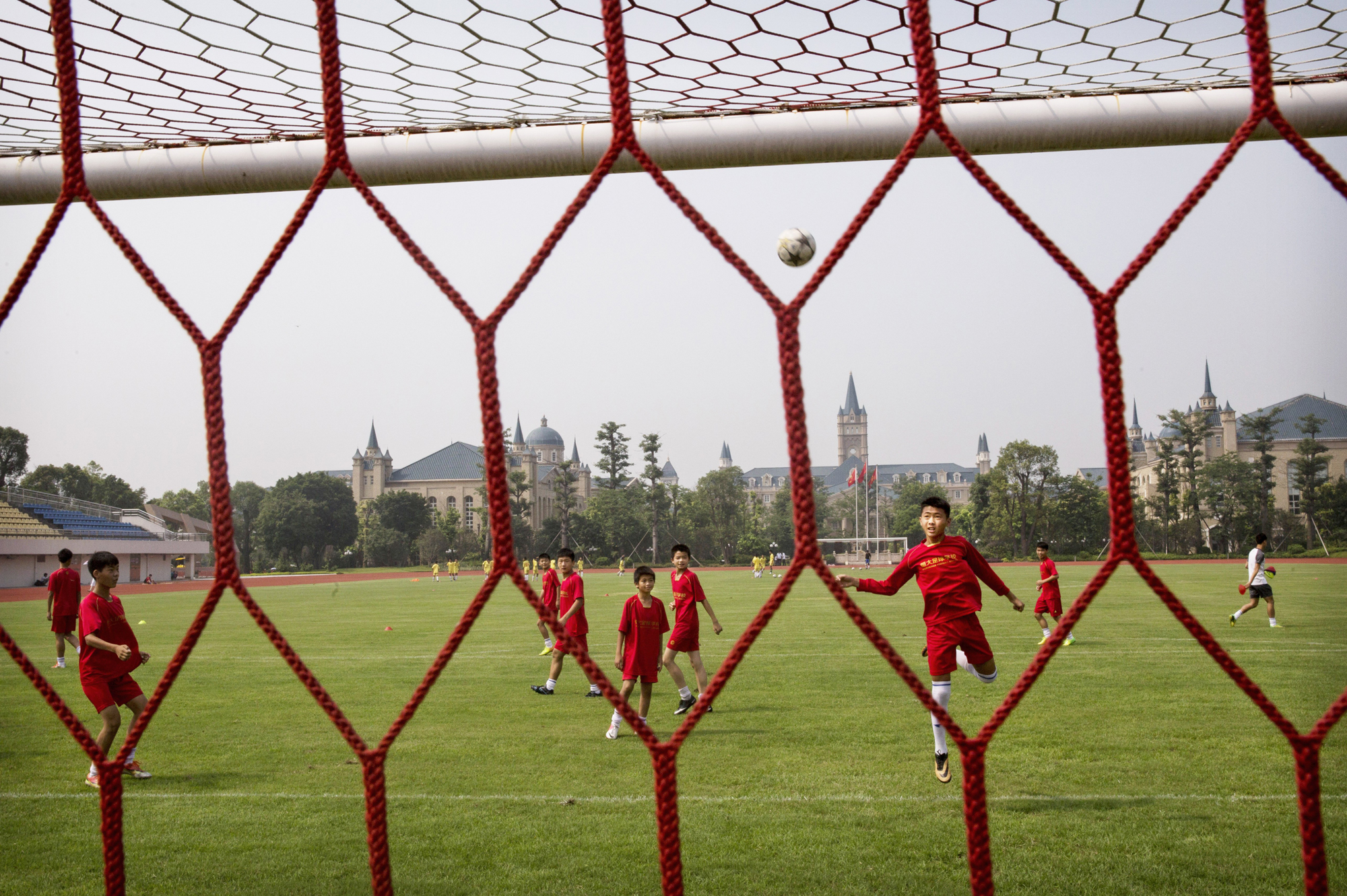 A student heads the ball during training on the main pitch at the Evergrande International Football School on June 14.