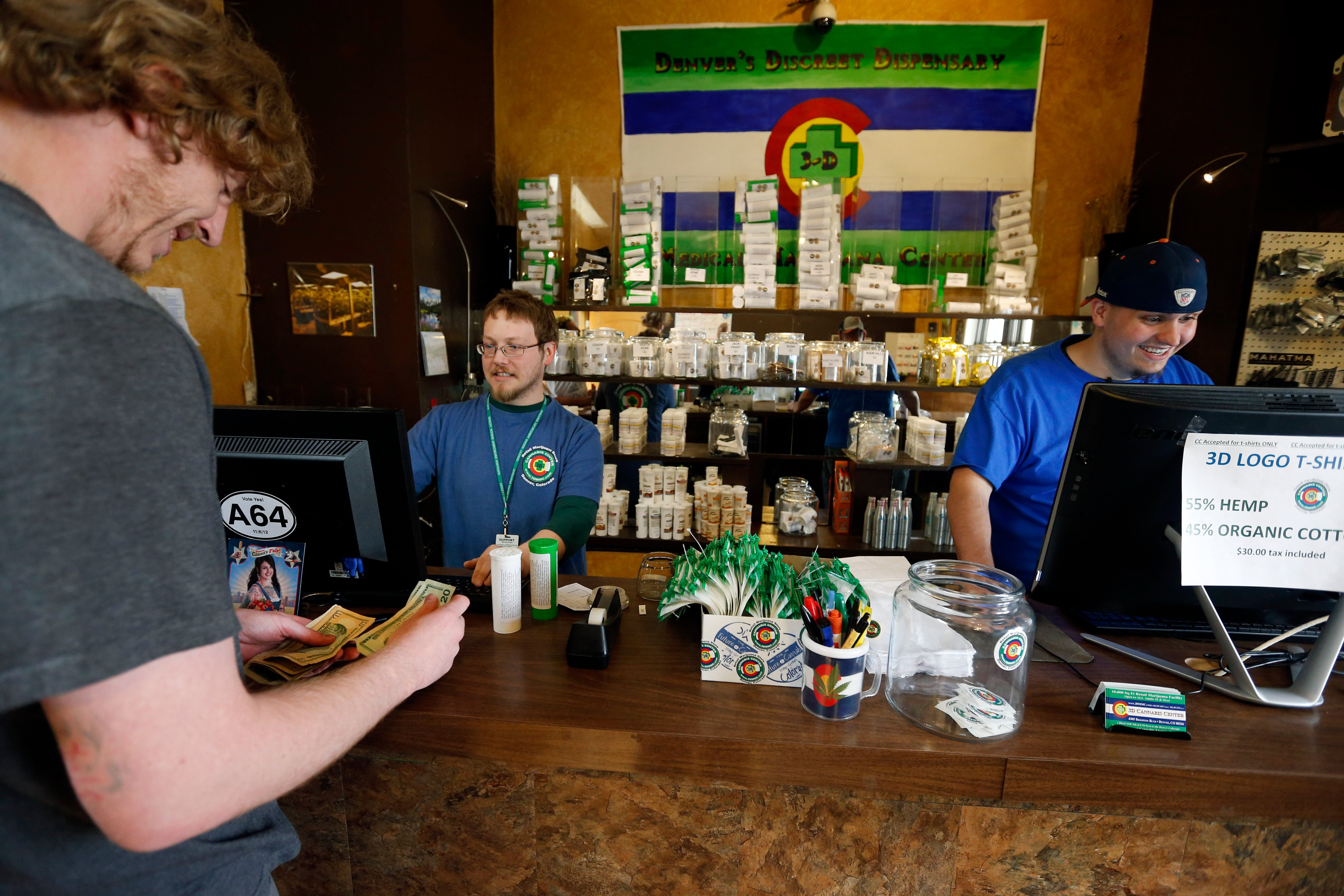A customer pays cash for retail marijuana at 3D Cannabis Center in Denver, May 8, 2014. (Brennan Linsley—AP)