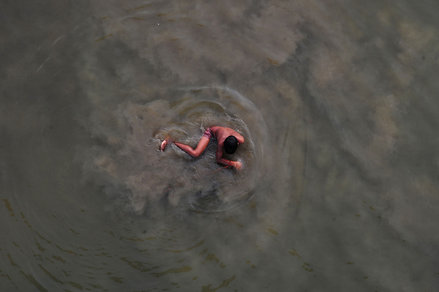 Jun. 18, 2014. An Indian boy cools off with a swim in the Yamuna river on a hot summer day in Allahabad.