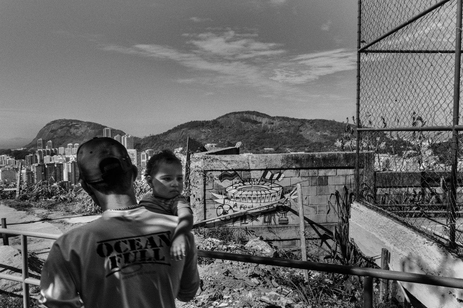 RIO DE JANEIRO, BRAZIL - JUNE 2014: Father and daughter after a soccer game in the favela of Santa Marta near Rio´s downtown, with a 2014 World Cup related graffiti. (Photo by Sebastián Liste/ Reportage by Getty Images)