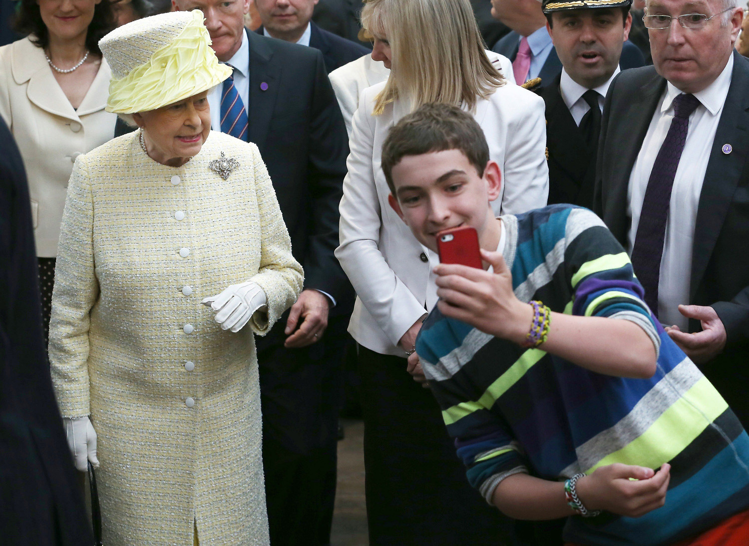 A local youth takes a selfie in front of Queen Elizabeth II during a visit to St. George's indoor market in Belfast, Northern Ireland on June 24, 2014.