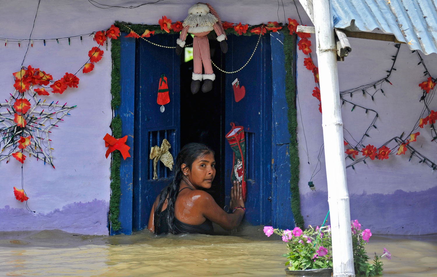 Xiomara Herrera, 13, enters her flooded home in El Porvenir, Colombia,on  Dec. 9, 2011. Torrential rains have caused devastating floods and widespread damage in the country for much of the past two years. Meteorologists blame the rains on La Nina.