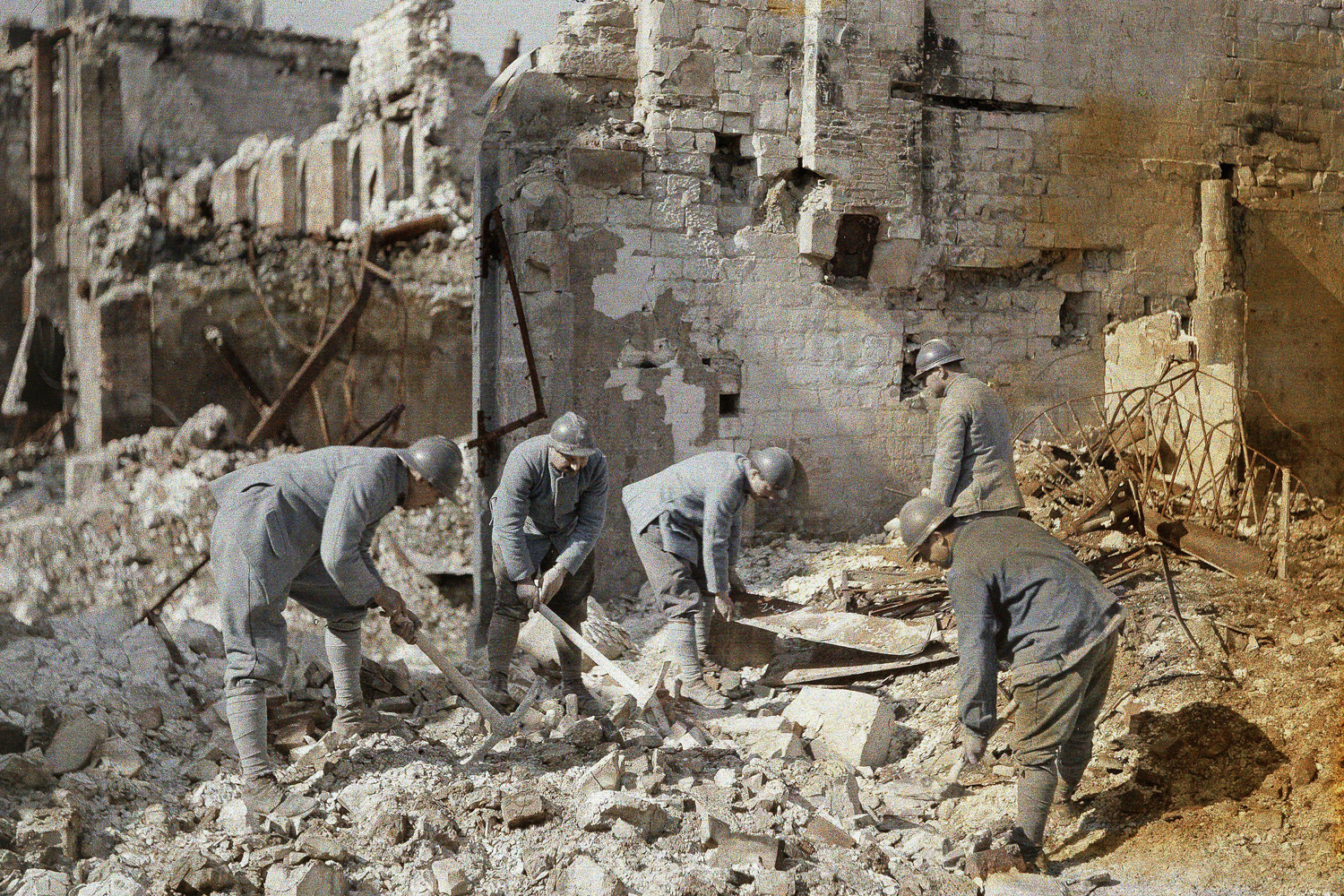 Five French soldiers clear rubble in the ruins of Reims, France, which was destroyed by German artillery and air raids, 1917.