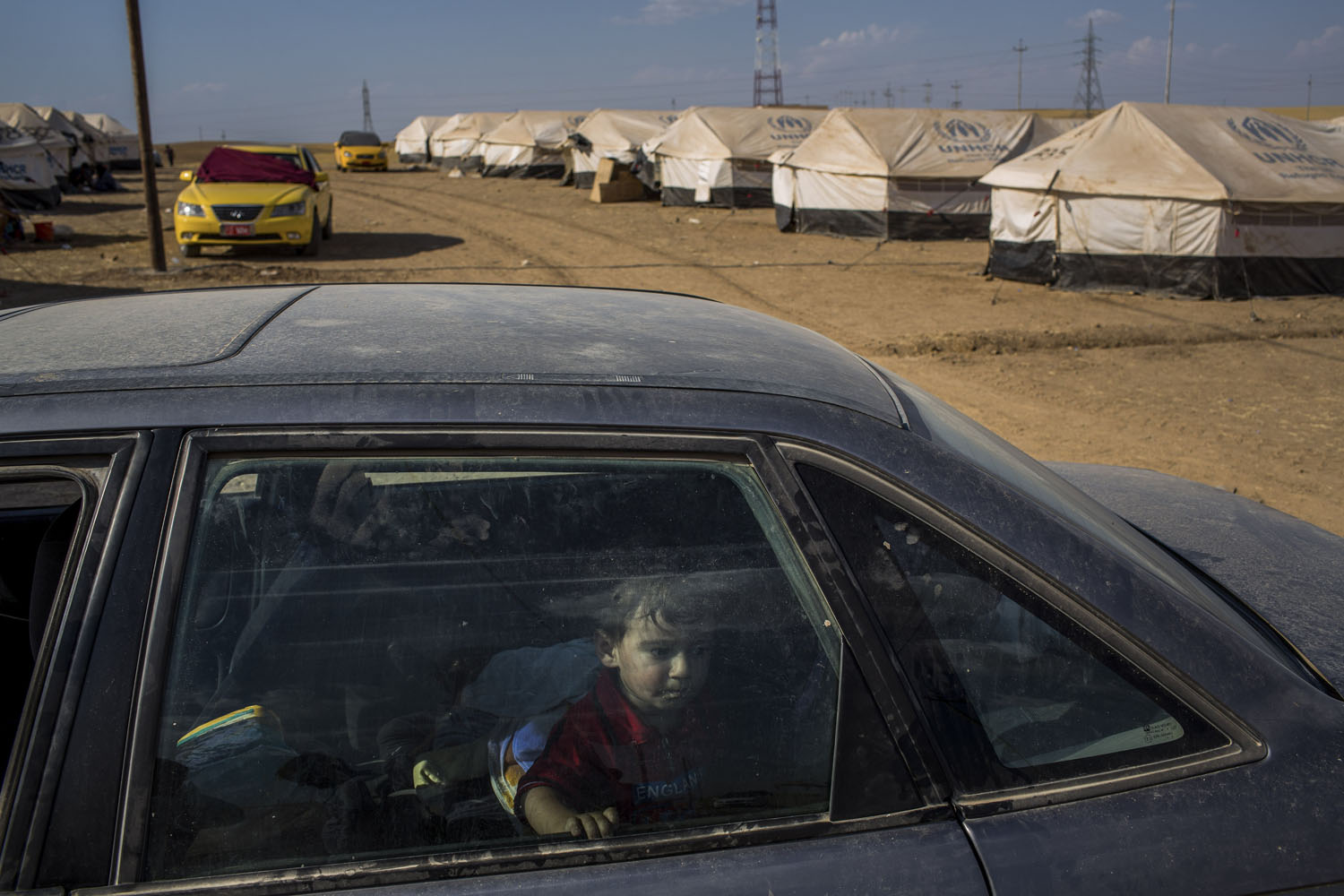 A child sits in his family's car at a United Nations-run camp between Mosul and Irbil, Iraq.