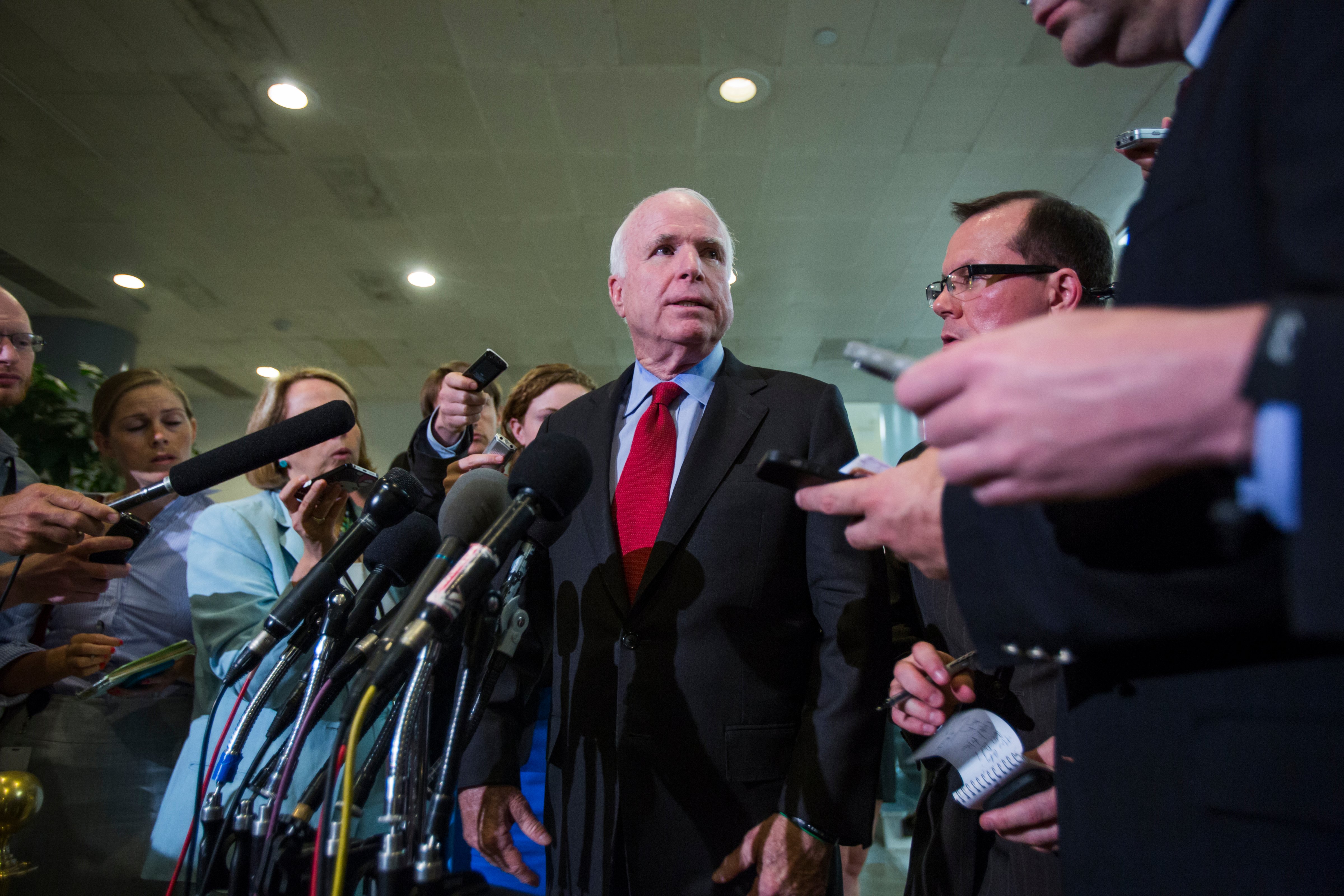 Republican Senator from Arizona John McCain, center, speaks to the media after a briefing by Obama administration officials to all U.S. Senators about the release of American hostage Bowe Bergdahl in the U.S. Capitol in Washington, D.C., June 4, 2014. (Jim Lo Scalzo—EPA)