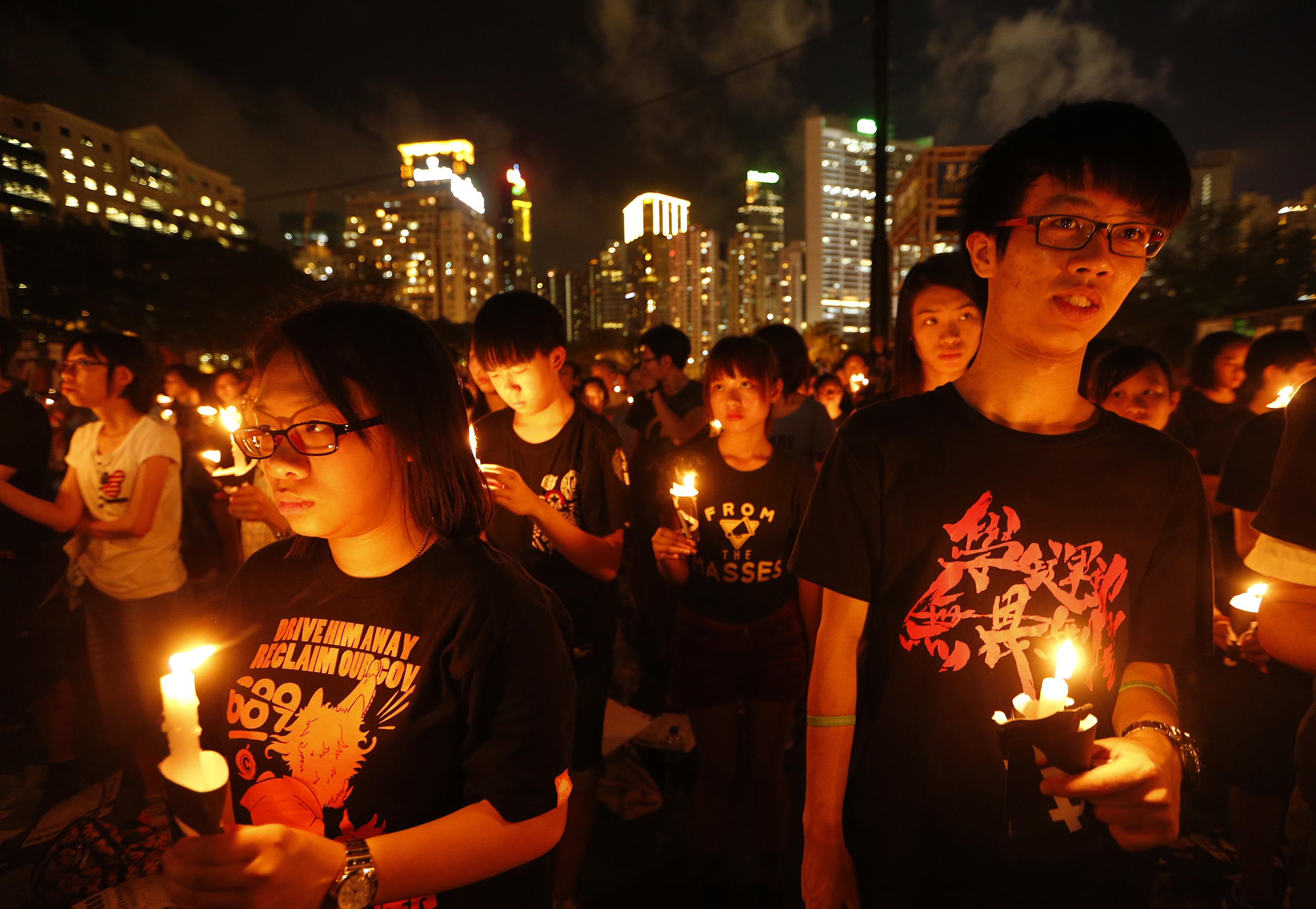 Participants hold candles as they join tens of thousands of people attending a candlelight vigil at Victoria Park in Hong Kong on June 4, 2014 (Kin Cheung—AP)