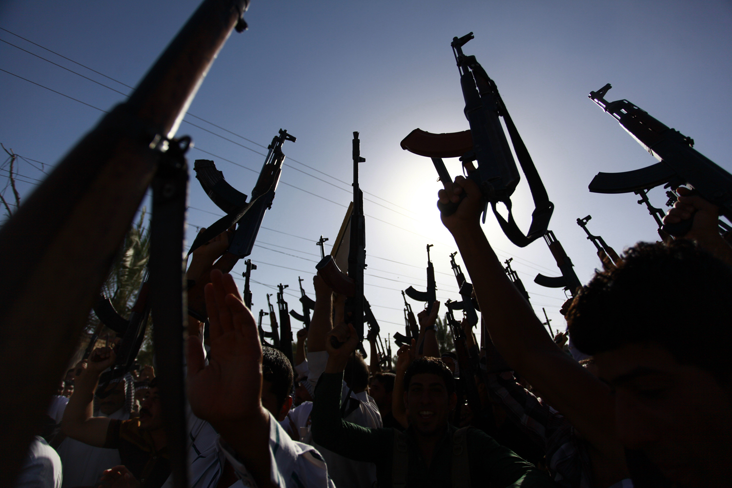 Iraqi Shiite tribesmen brandish their weapons as they gather to show their willingness to join Iraqi security forces in the fight against Jihadist militants who have taken over several northern Iraqi cities, on June 17 2014, in the southern Shiite Muslim shrine city of Najaf. (Haidar Hamdani—AFP/Getty Images)