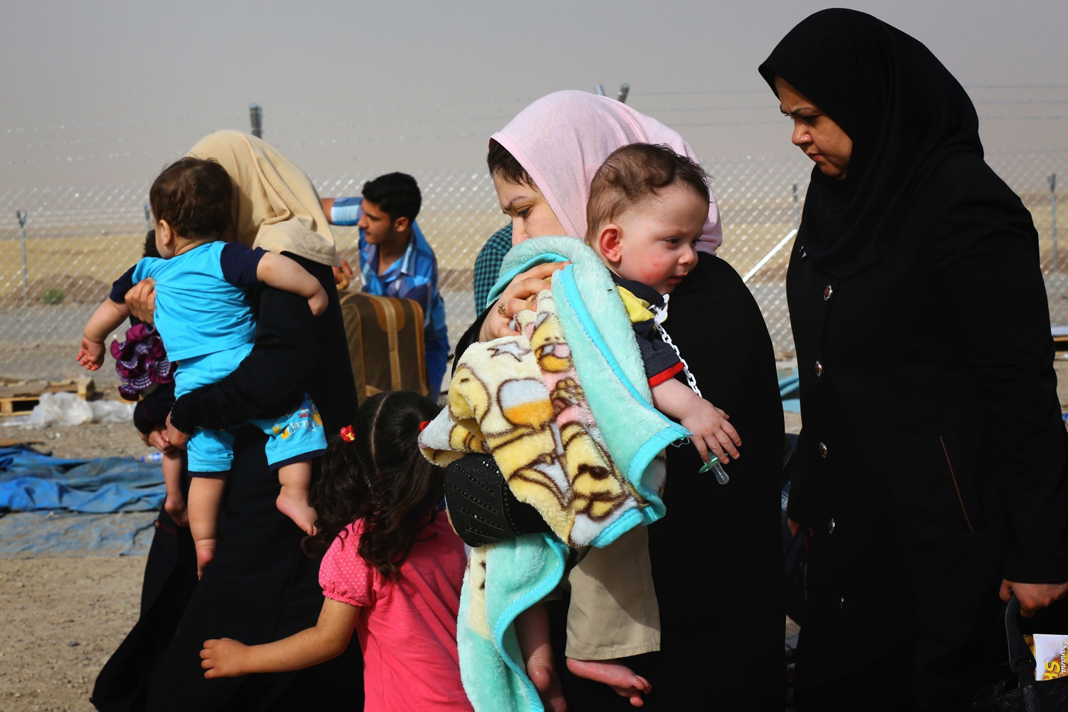 Families fleeing the violence in the Iraqi city of Mosul arrive at a checkpoint on the outskirts of Erbil, in Iraq's Kurdistan region June 12, 2014.