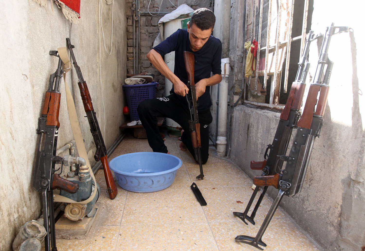 A Shiite man cleans weapons as he gets ready to defend his Sadr City district in case of an attack by Sunni extremists, on June 13 in Baghdad.