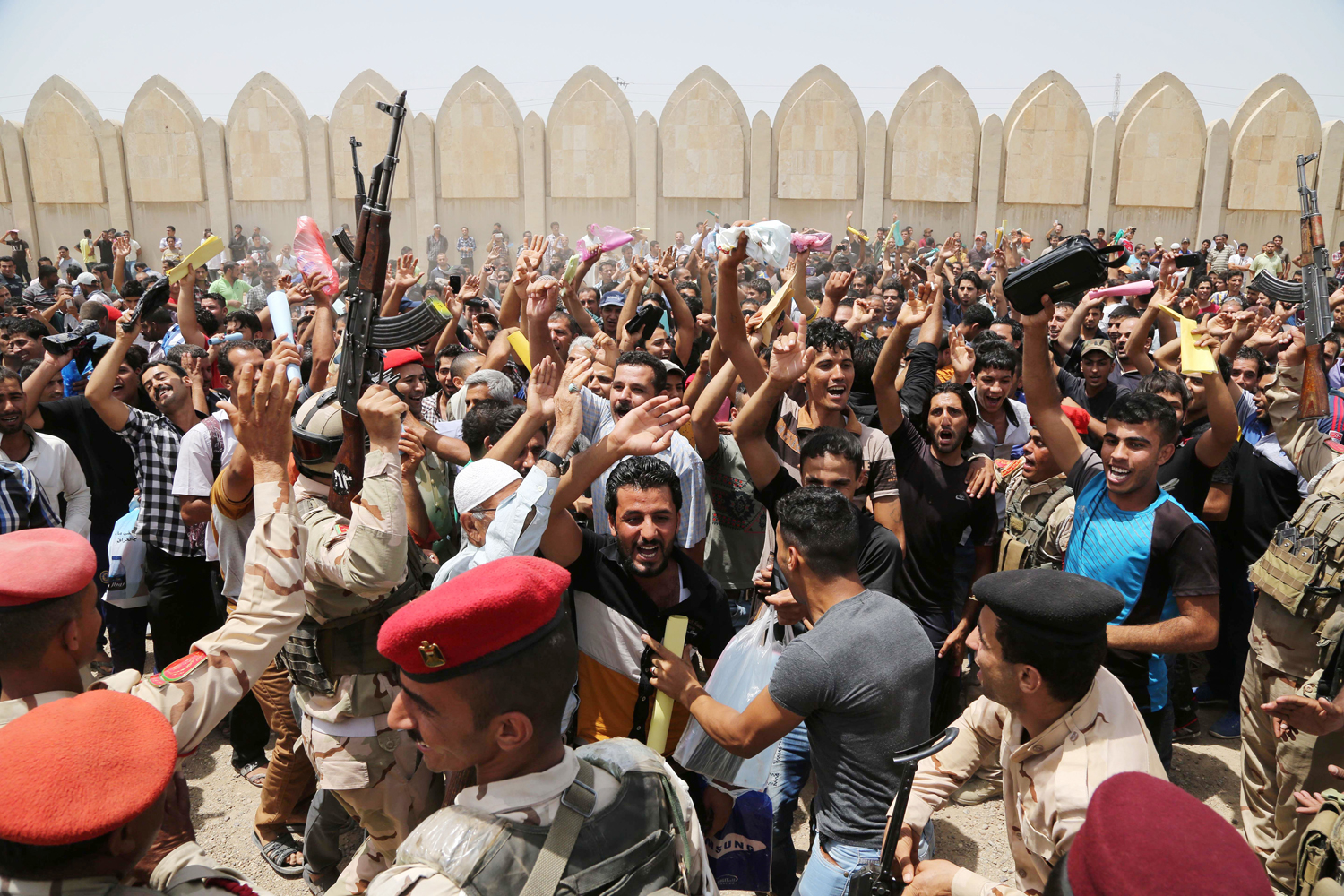 Men chant slogans against the al-Qaida breakaway group Islamic State of Iraq and Greater Syria (ISIS), outside of the main army recruiting center to volunteer for military service in Baghdad, June 12, 2014.