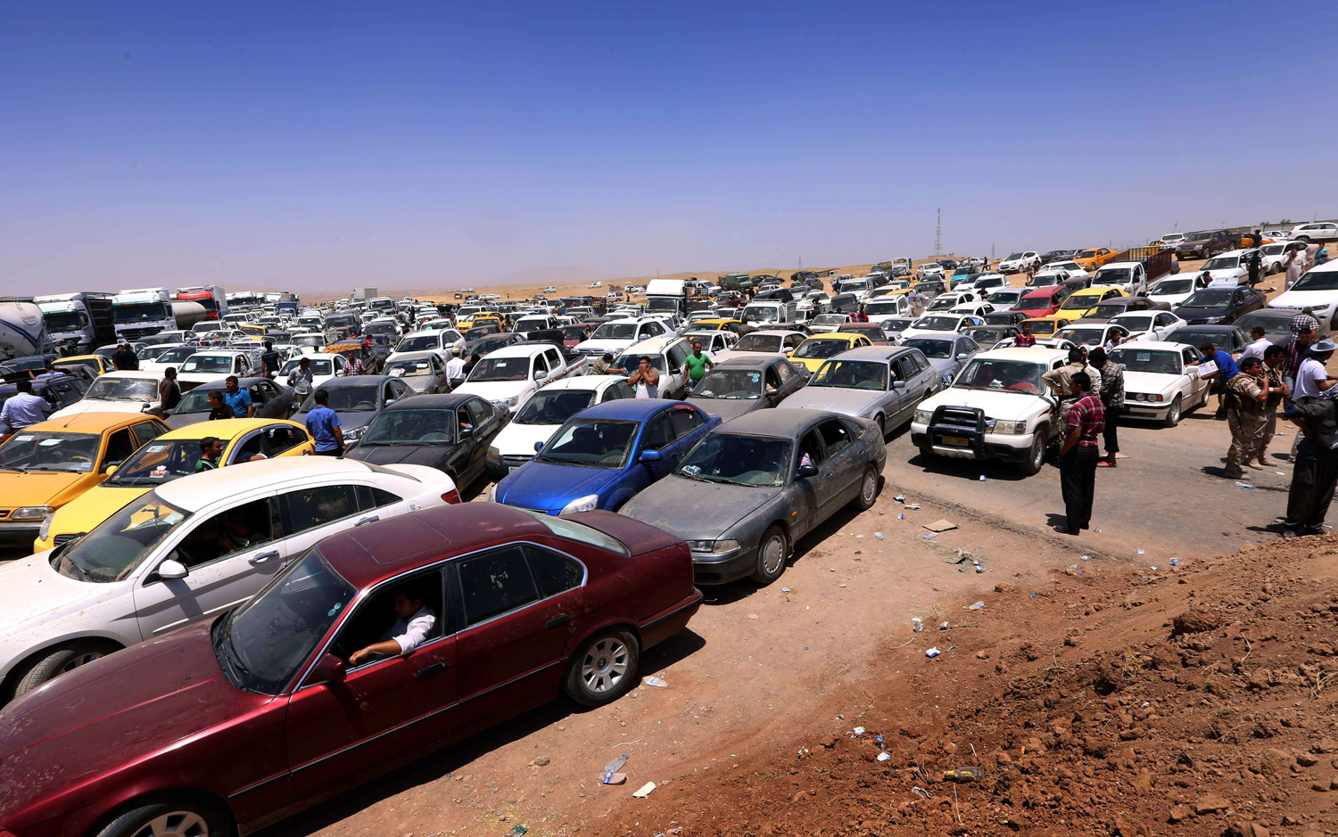 Iraqis fleeing violence in Nineveh province wait in their vehicles at a Kurdish checkpoint in Aski Kalak, 25 miles west of Arbil, the capital of the autonomous Kurdish region of northern Iraq, on June 10, 2014. (Safin Hamed—AFP/Getty Images)