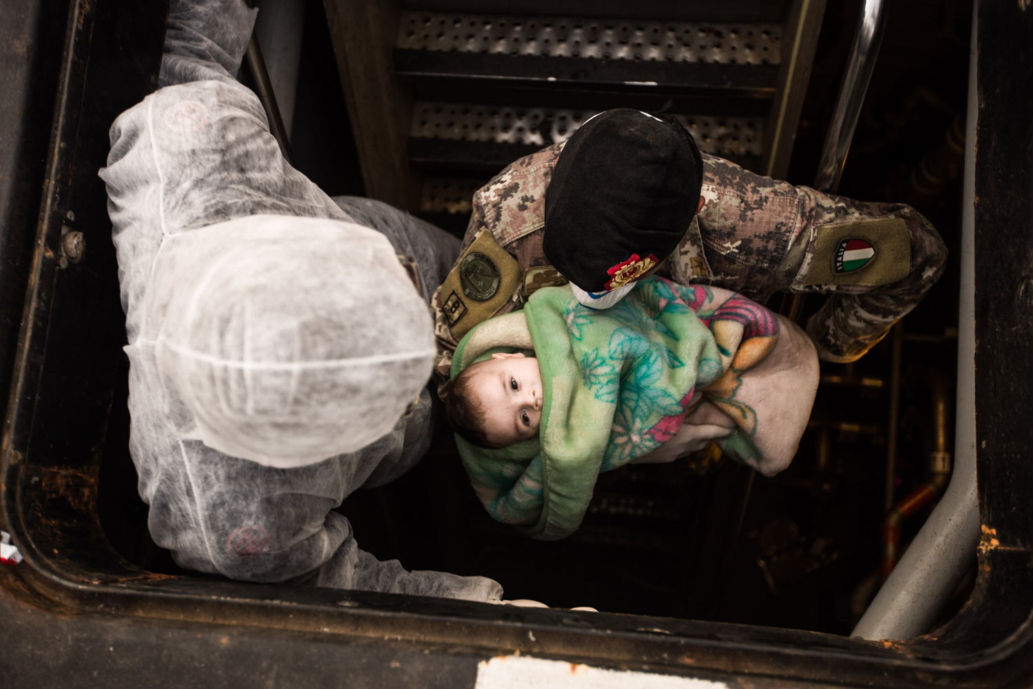 Italian soldier carries a Syrian child on a ship after the Italian navy rescued 443 Syrian asylum seekers off a fishing vessel, June 5.