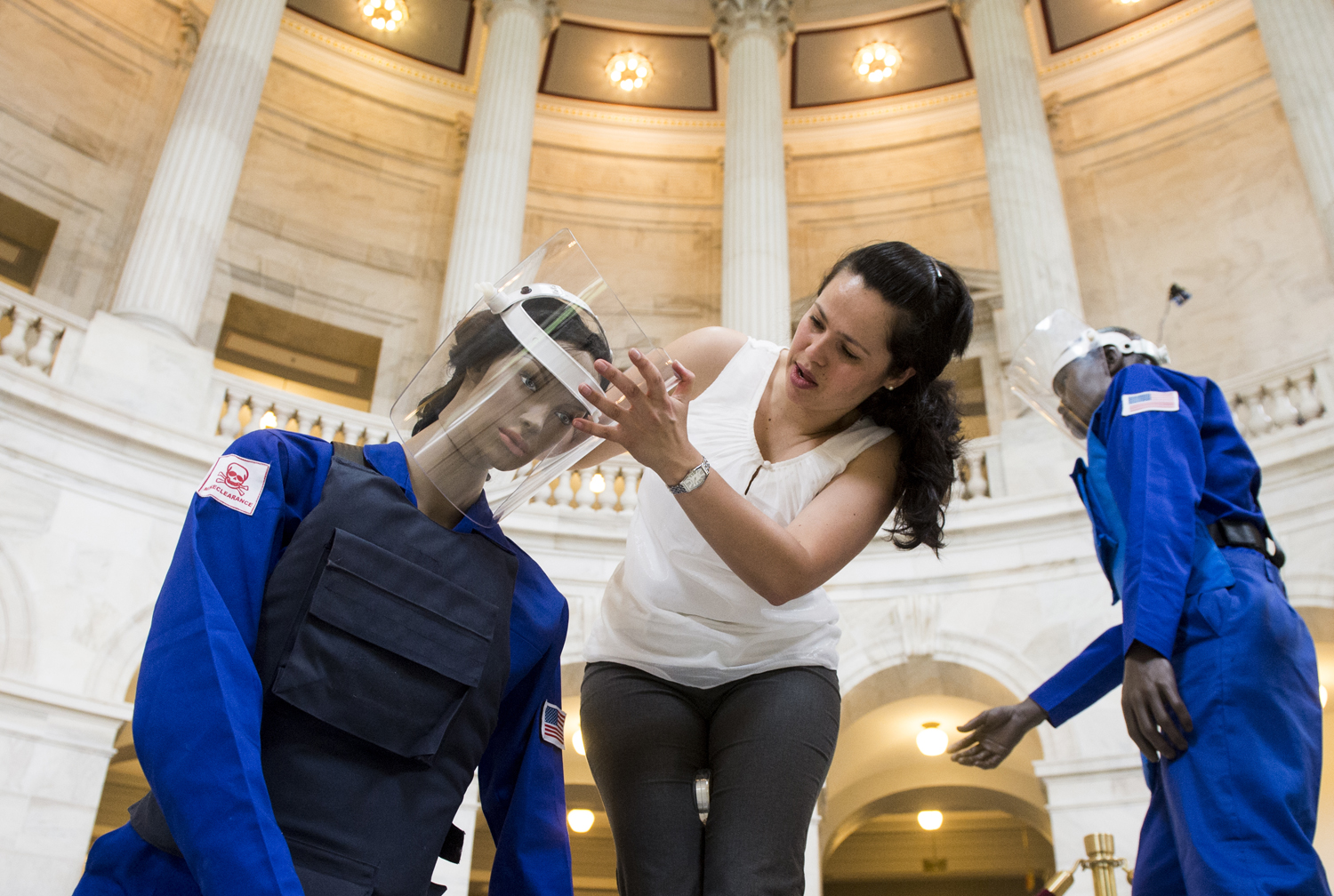 Claudia DelGado, of the Halo Trust, helps set up mannequins for an exhibit in the Russell Senate Office Building on May 6, 2013, on ridding the world of land mines. 