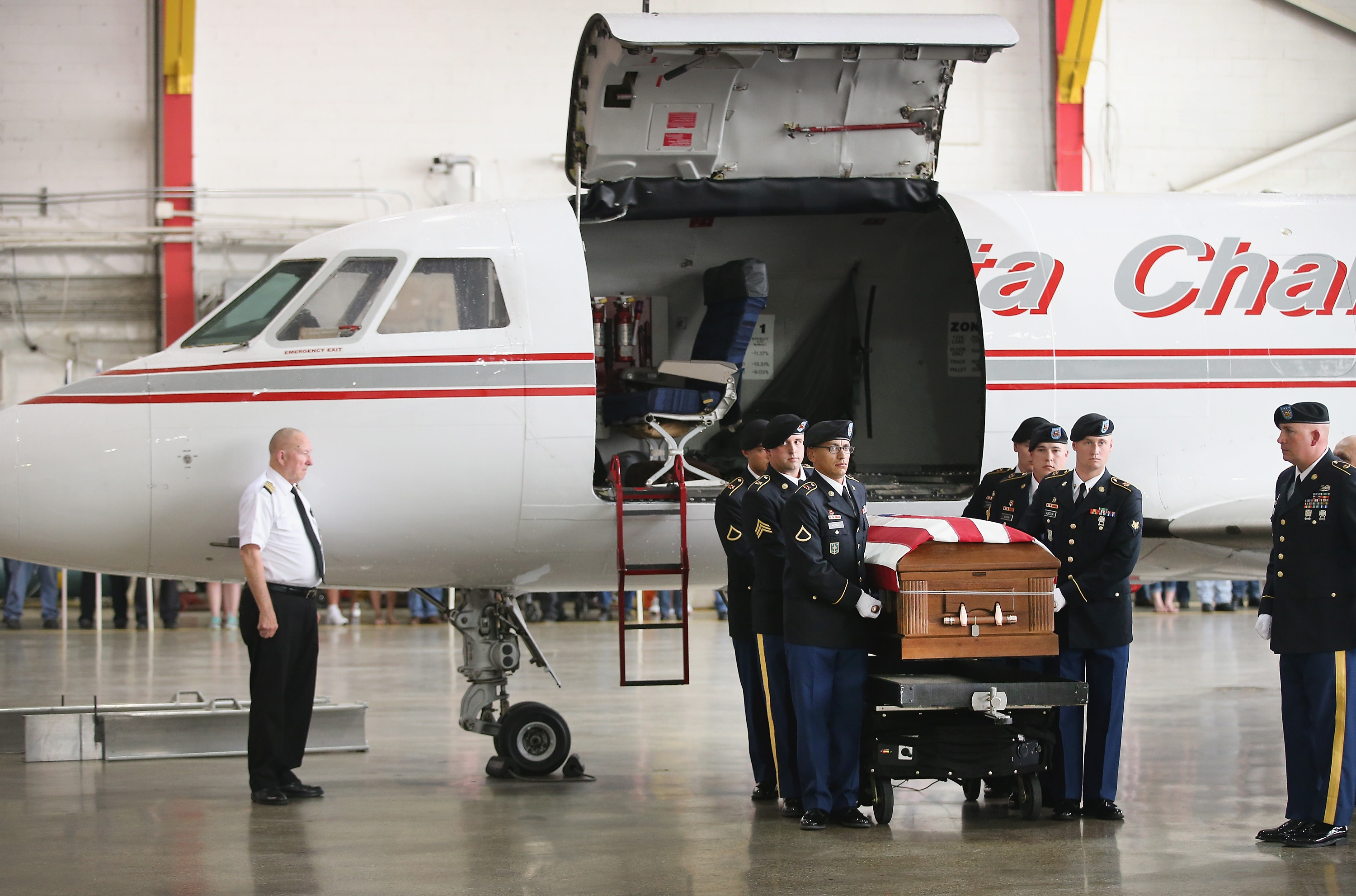 Soldiers carry the remains of Army Pfc. Aaron Toppen to a hearse after they arrived at Midway Airport on a charter aircraft from Dover Air Force Base on June 21, 2014 in Chicago.