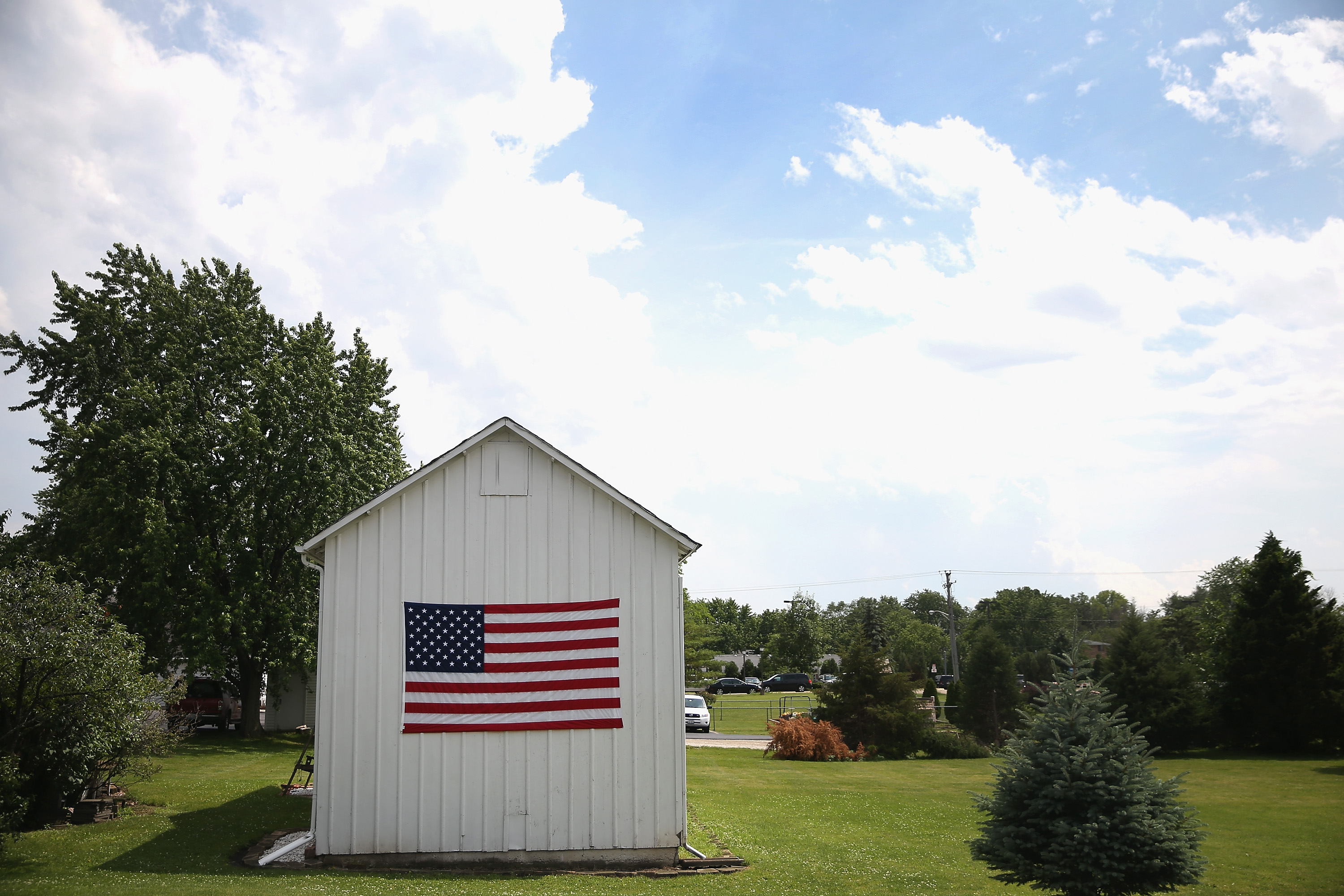 A flag is attached to a barn next to the funeral home where the remains of Army Pfc. Aaron Toppen were taken on June 21, 2014 in Mokena, Ill.