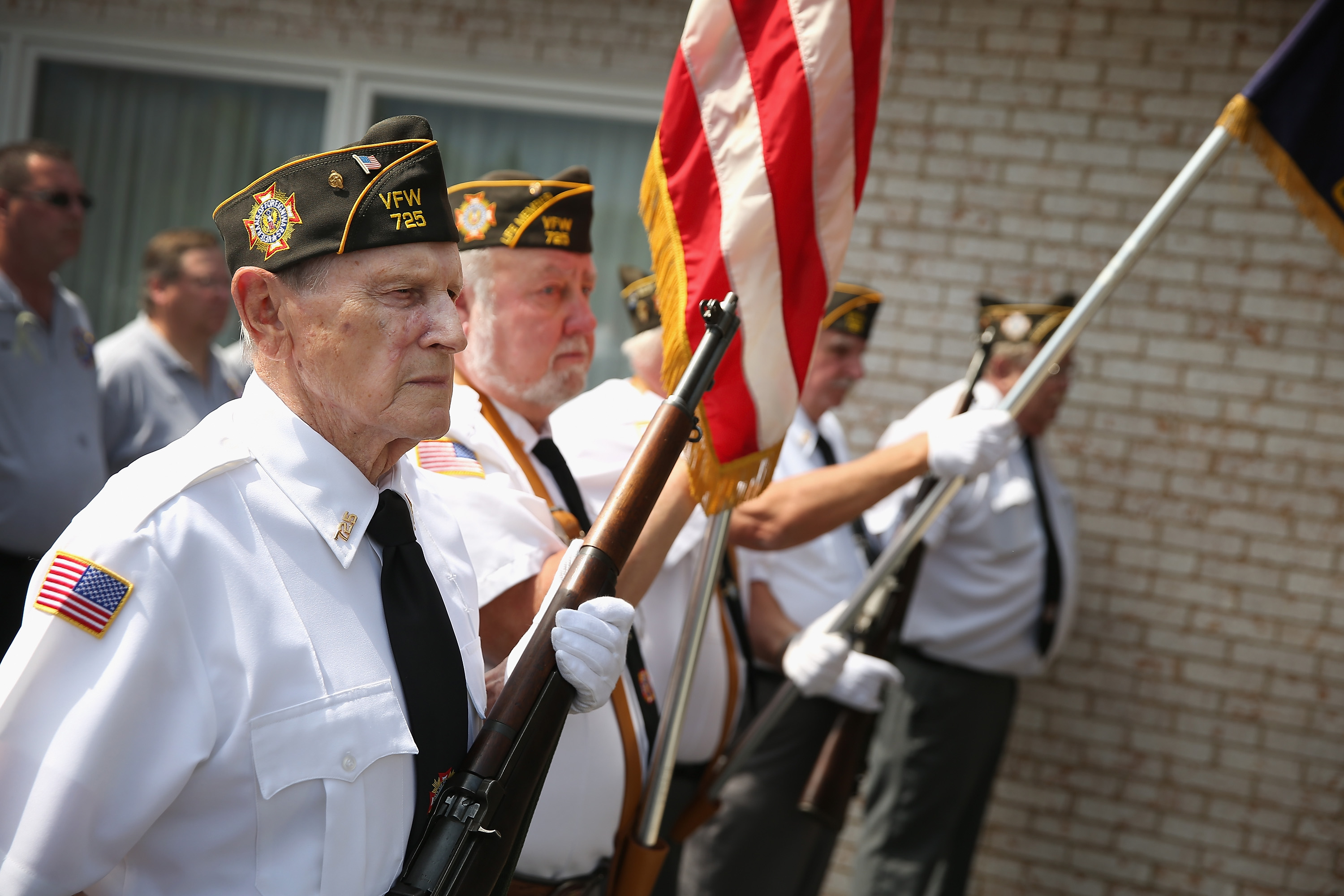 A VFW honor guard stands at attention as the remains of Army Pfc. Aaron Toppen are carried into the funeral home on June 21, 2014 in Mokena, Ill.